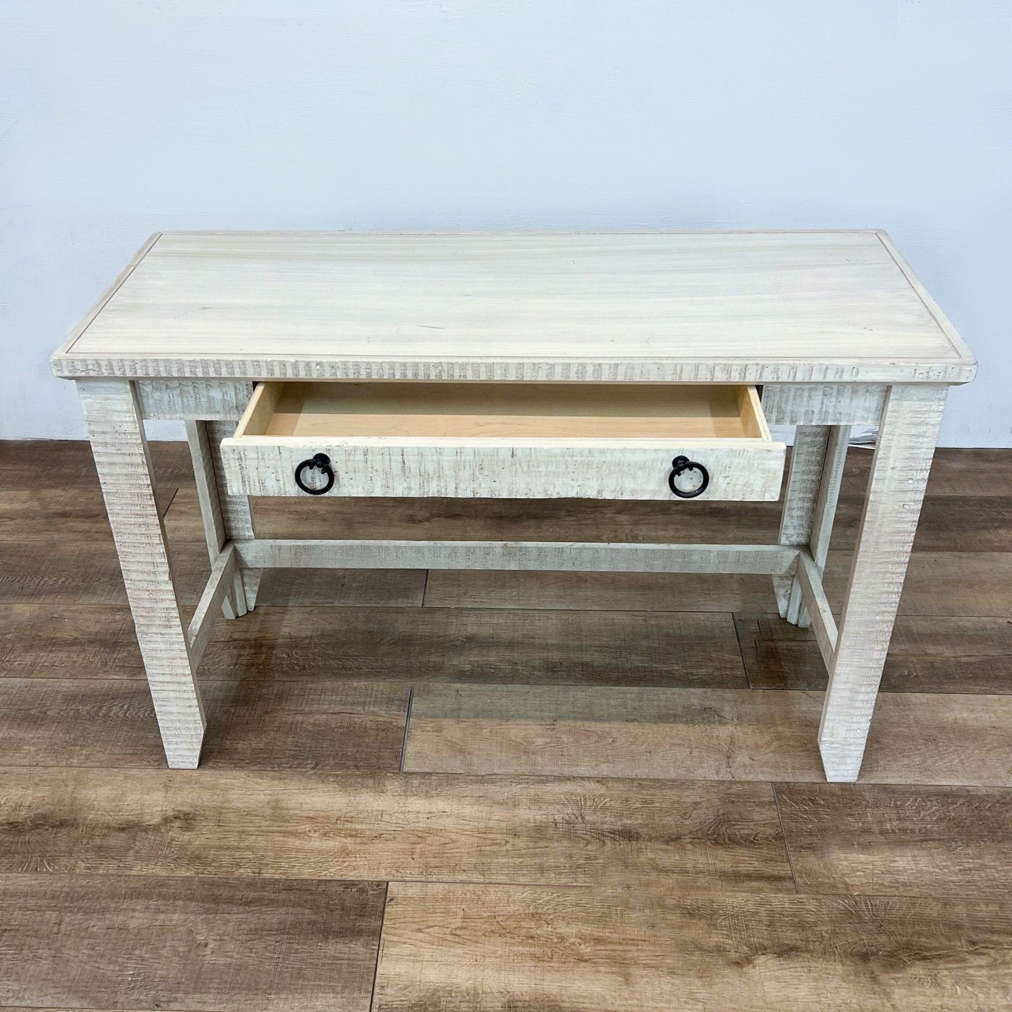 Open drawer on a Reperch side table showing the interior, with a textured off-white finish and black ring handles.