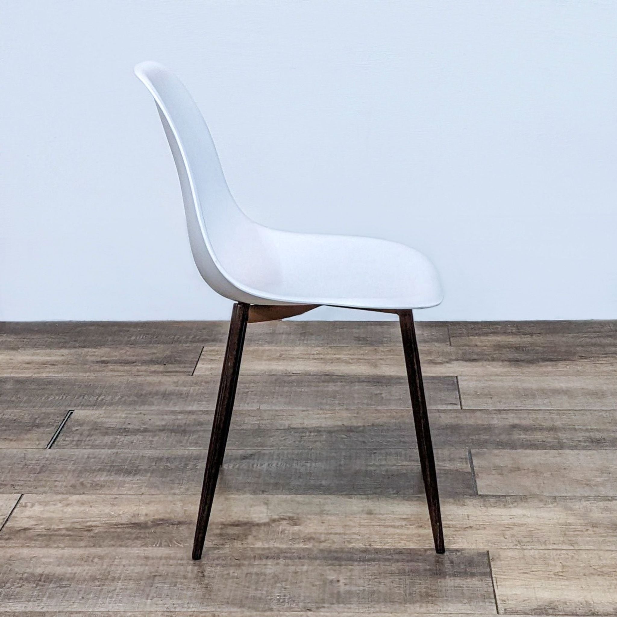 Alt text 2: Close-up of the Reperch modern dining chair's seat attachment to walnut-look metal legs.