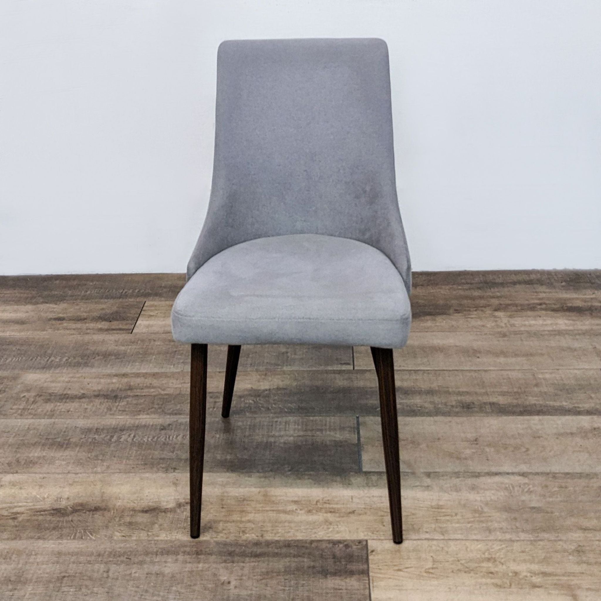 Reperch mid-century modern dining chair with cushioned gray fabric upholstery and curved wood seat frame on walnut-finish metal legs.