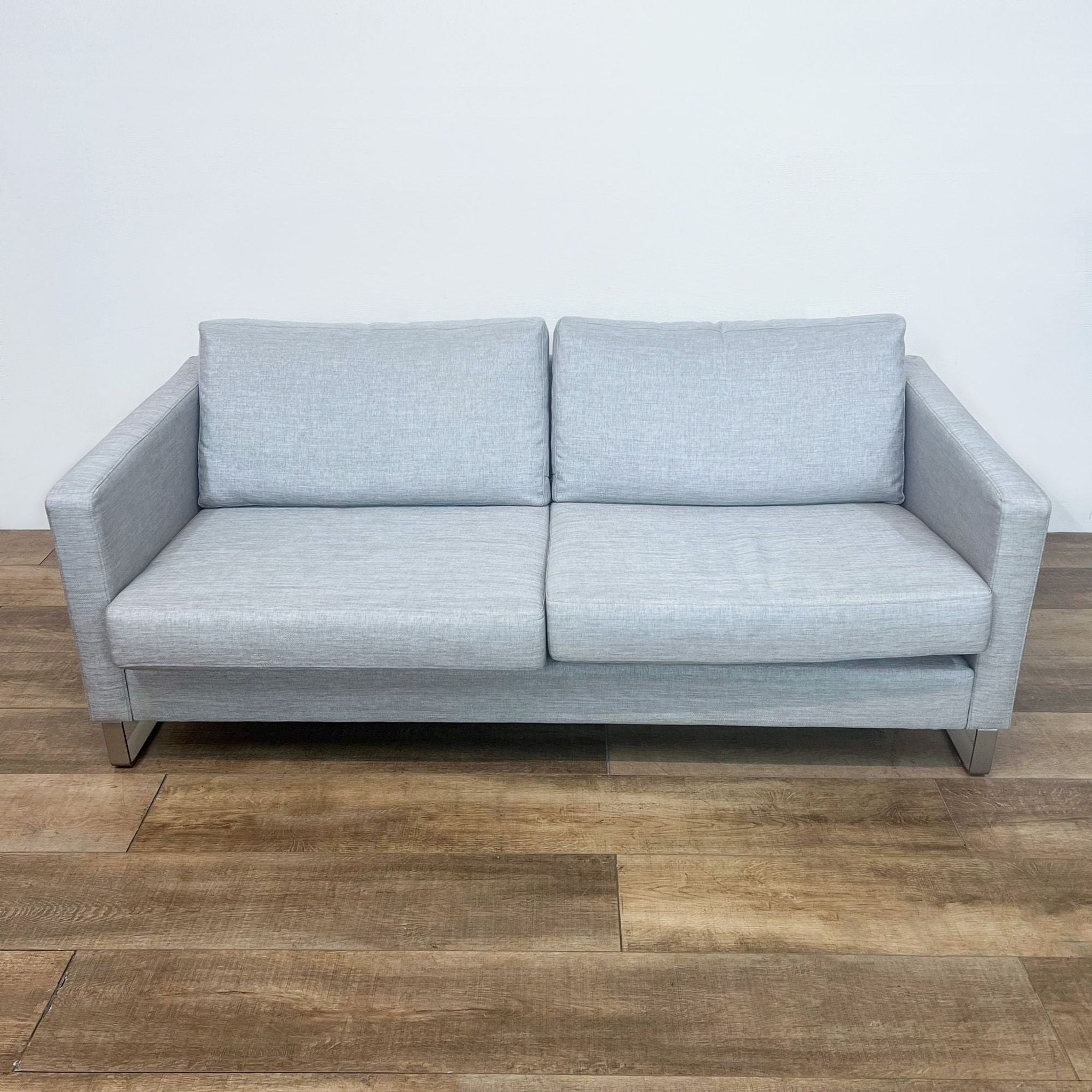 Alt text 1: BoConcept 3-seat designer gray sofa showcasing clean lines, narrow arms, and metal legs, viewed from the front.