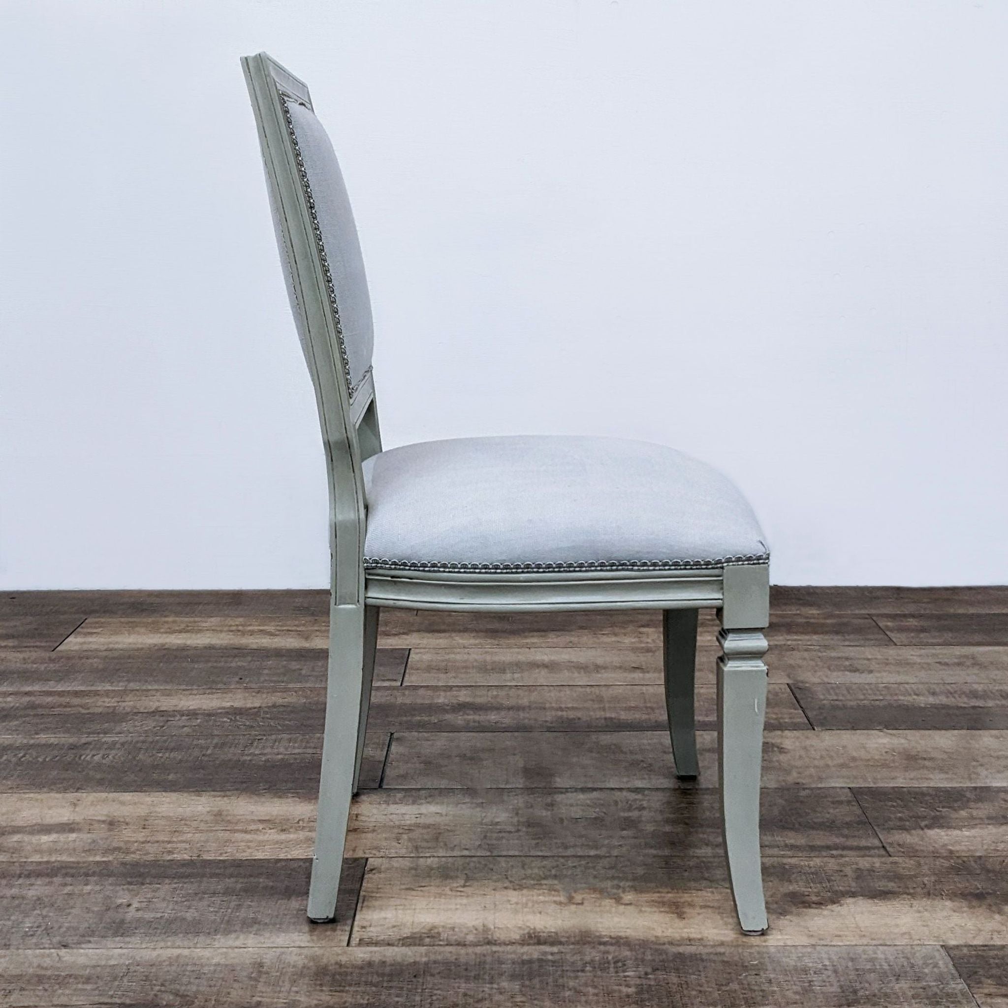 Weathered wooden dining chair by Reperch with a vintage French design, featuring an upholstered cushioned seat and backrest.