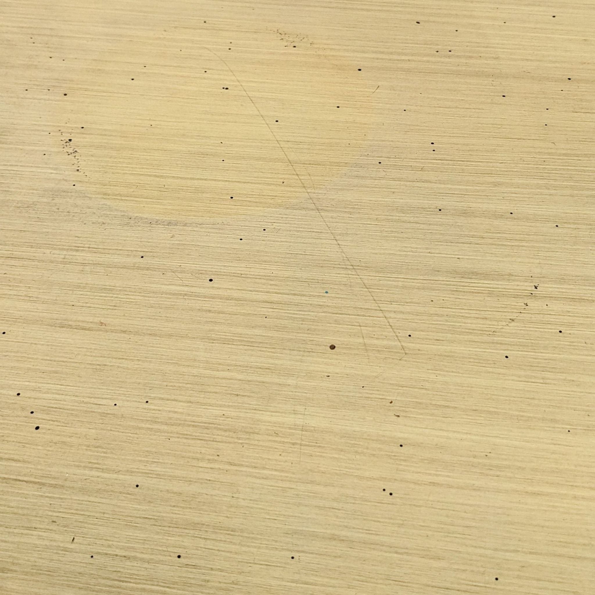 Close-up texture of a Reperch brand end table surface with small black speckles and subtle scratches.