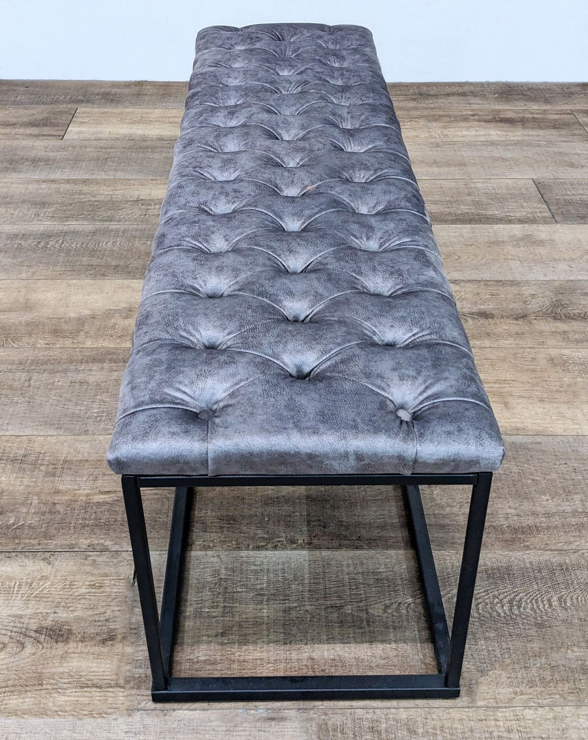 Reperch Padded Tufted Top Leather 52" Bench with Dark Metal Frame on wooden floor.