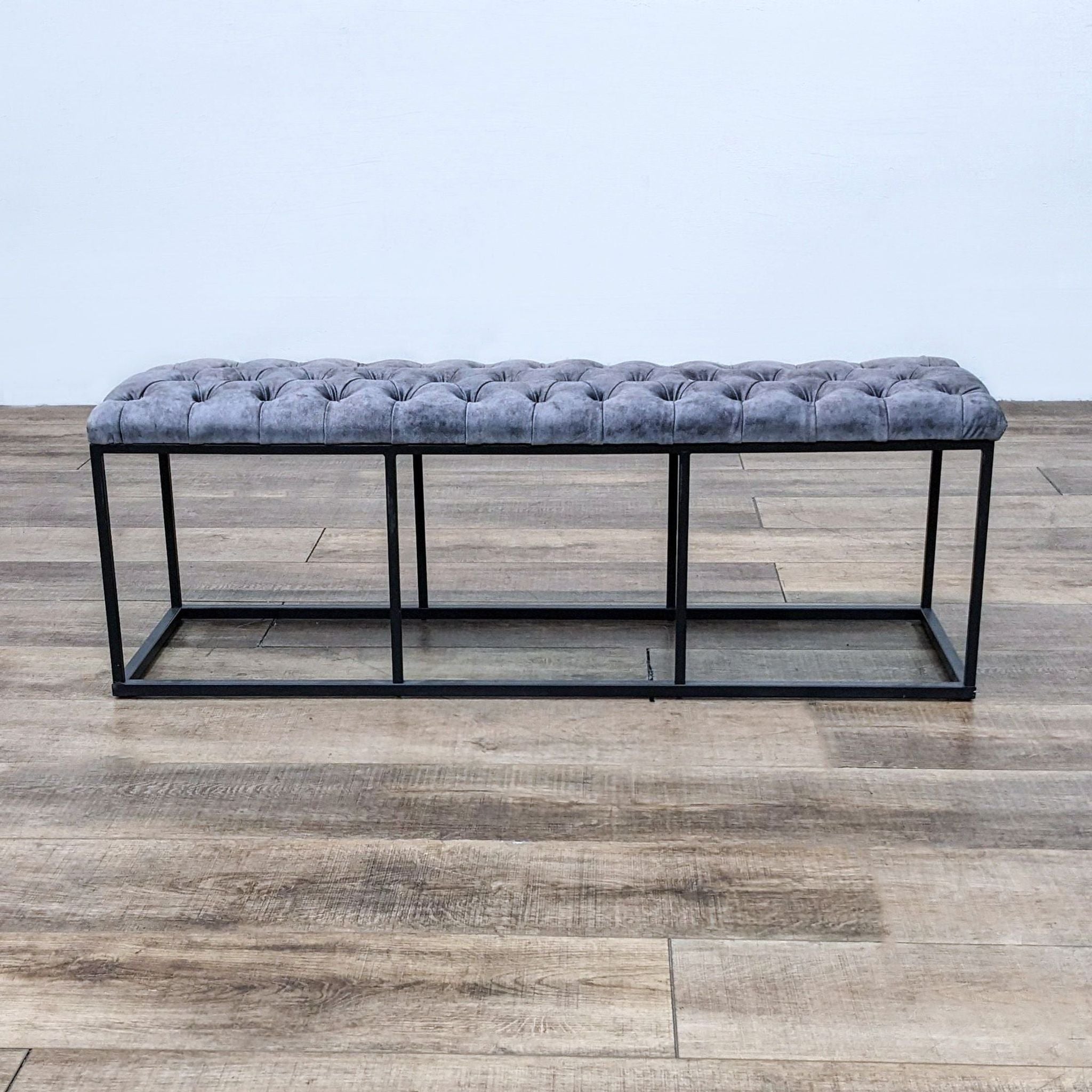 Reperch brand padded tufted top leather 52" bench with dark metal frame on wooden floor.