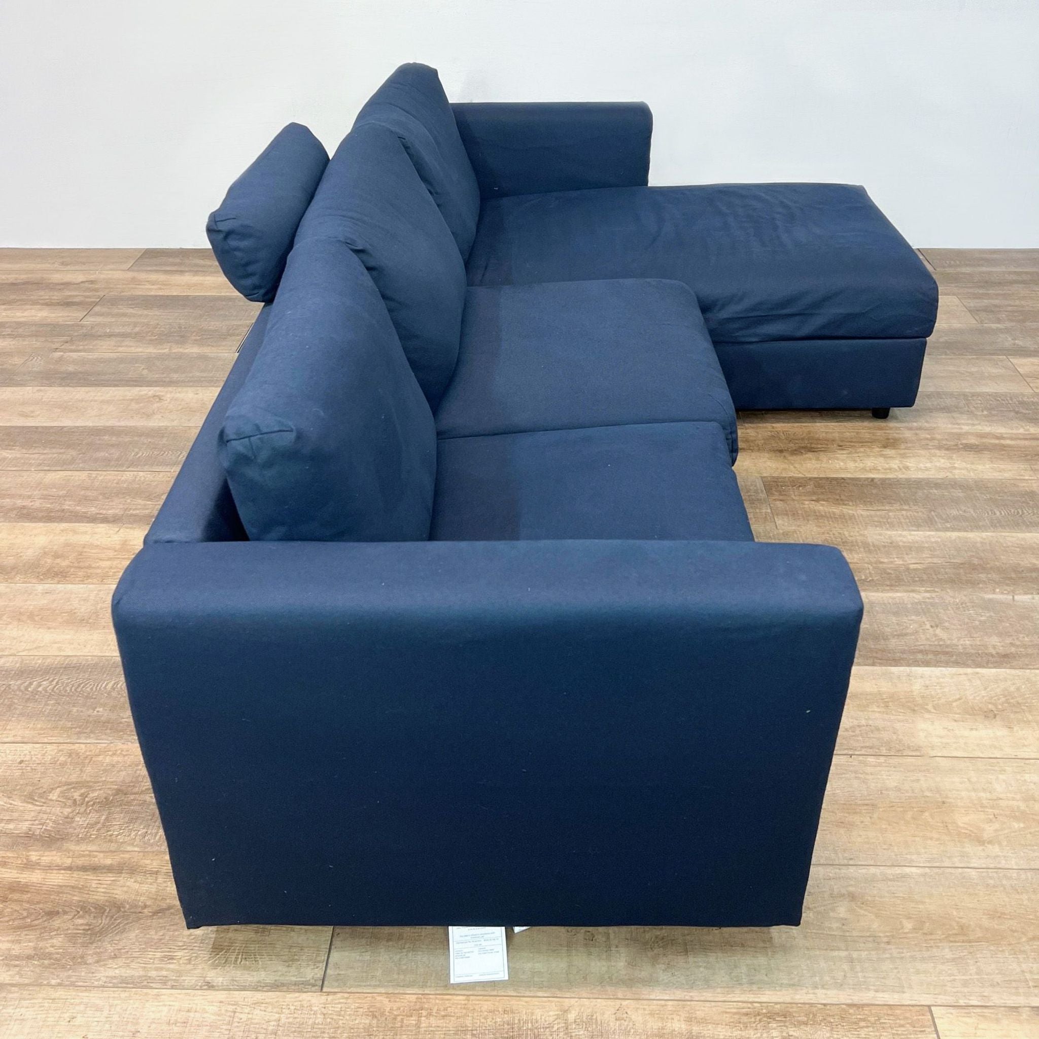 Front angle view of a blue Ikea sectional sofa with a chaise lounge, demonstrating the piece's sleek and contemporary style.