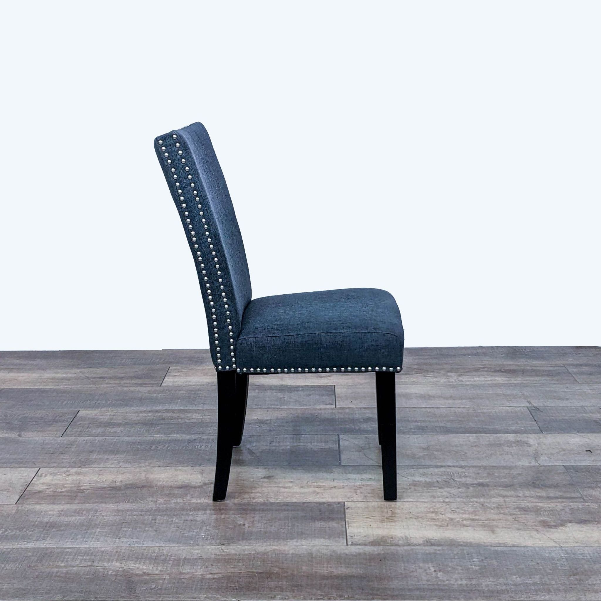 Reperch contemporary dining chair, side view, showcasing blue fabric, silver nailhead detailing, and espresso legs.