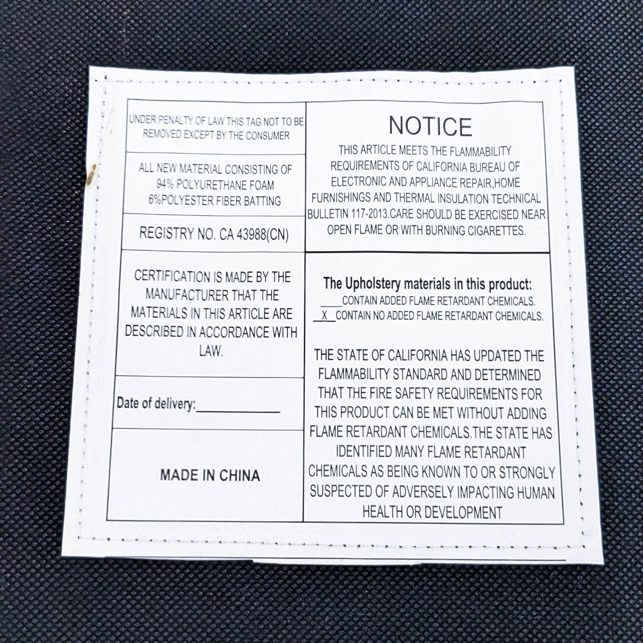 Alt text: Close-up of a law label on a Reperch modern dining chair with details on material composition and flammability notice.