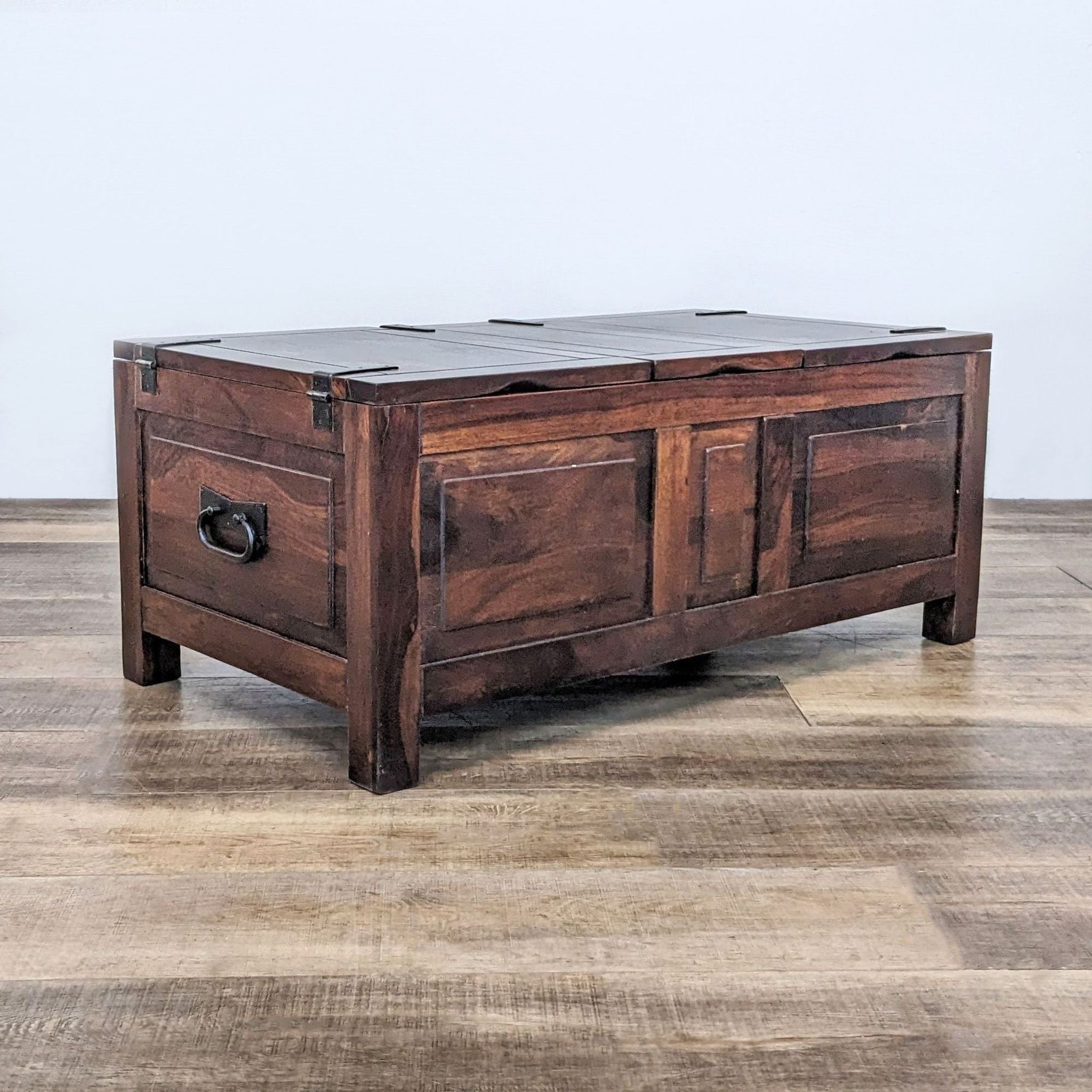 Reperch brand wooden coffee table with closed lift-top storage and black metal hardware on wooden floor.