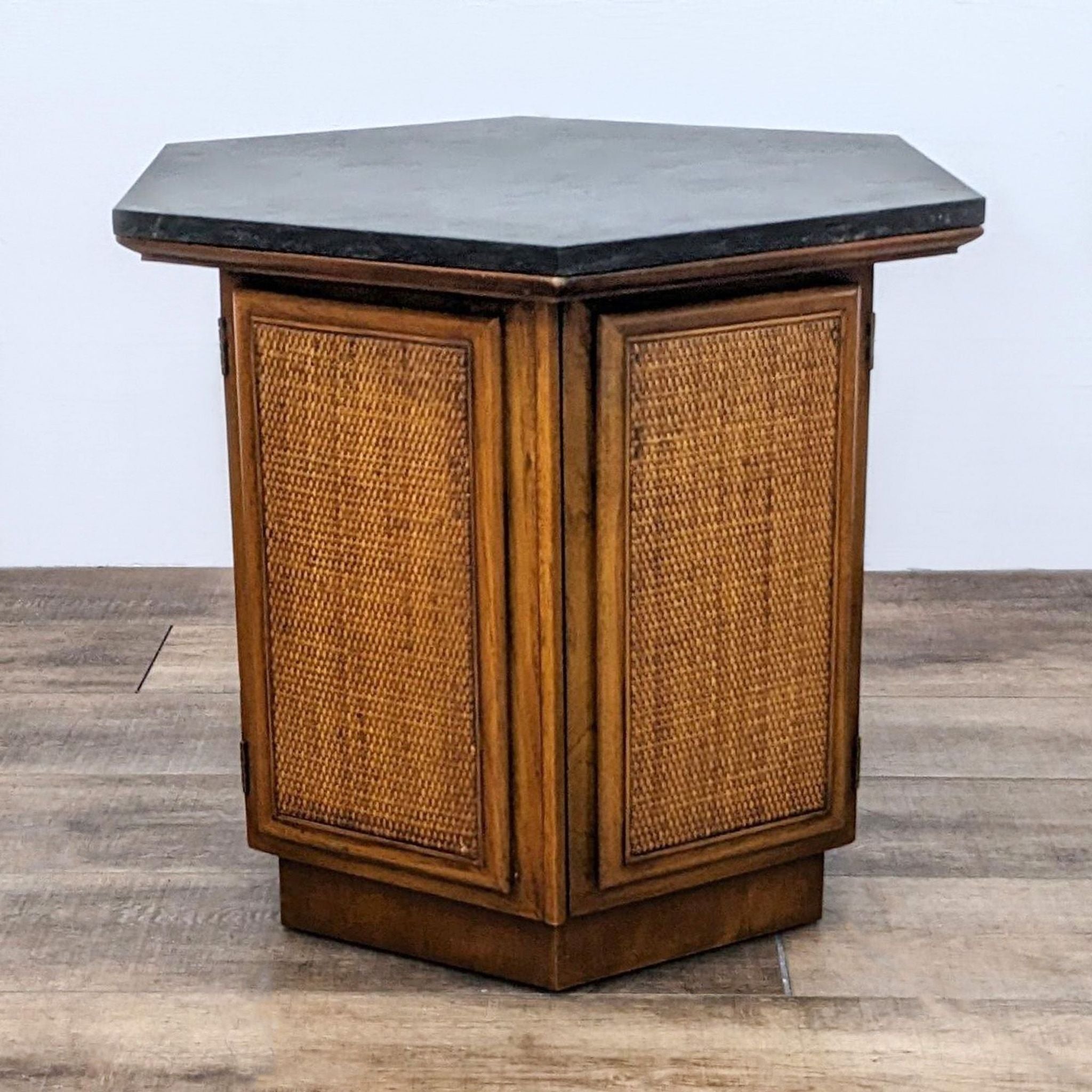 Reperch end table with closed rattan-faced cabinet doors and hexagonal dark top.