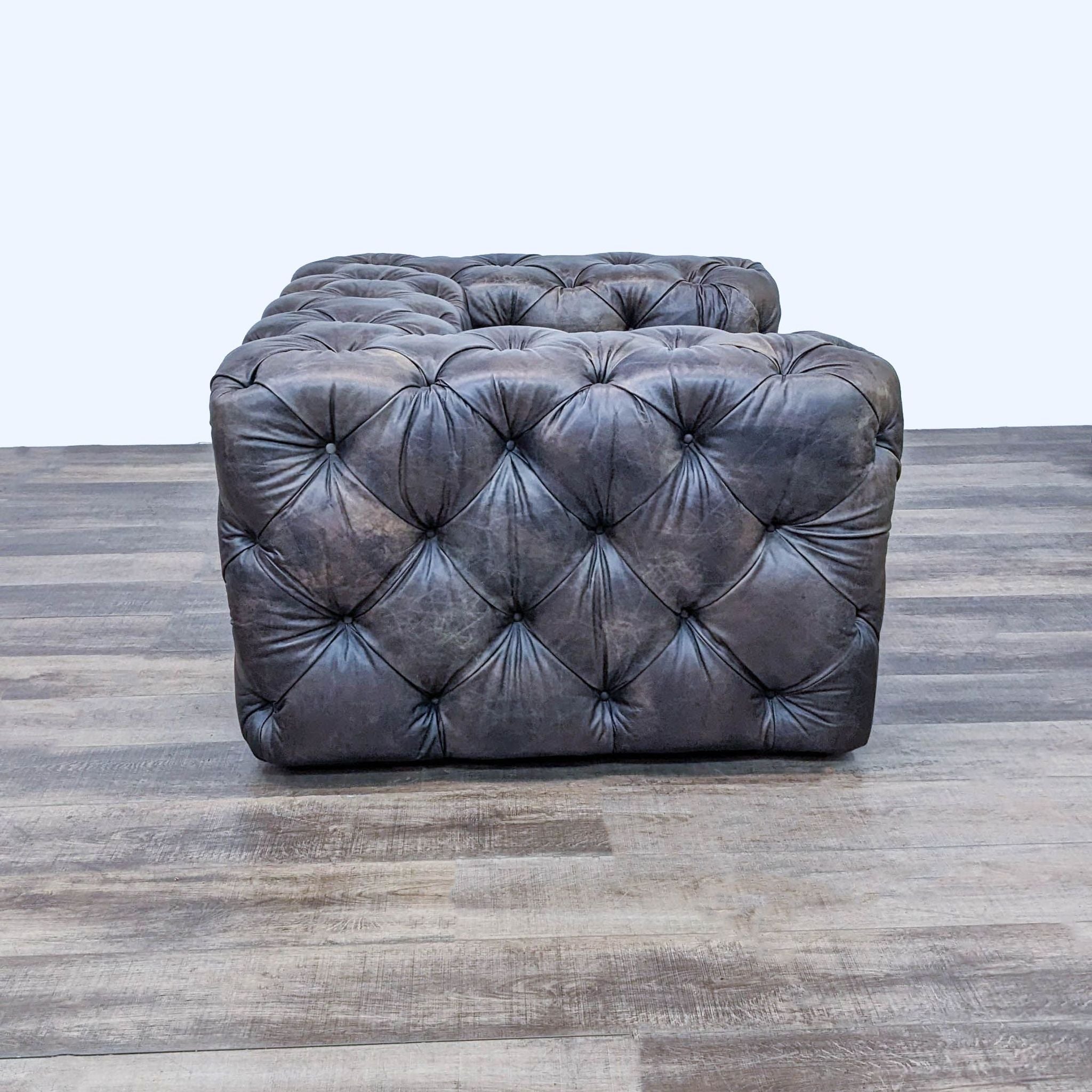 Alt text 2: Side view of a button-tufted SoHo club chair by Restoration Hardware in dark leather, highlighting the luxurious plush padding and low profile design.