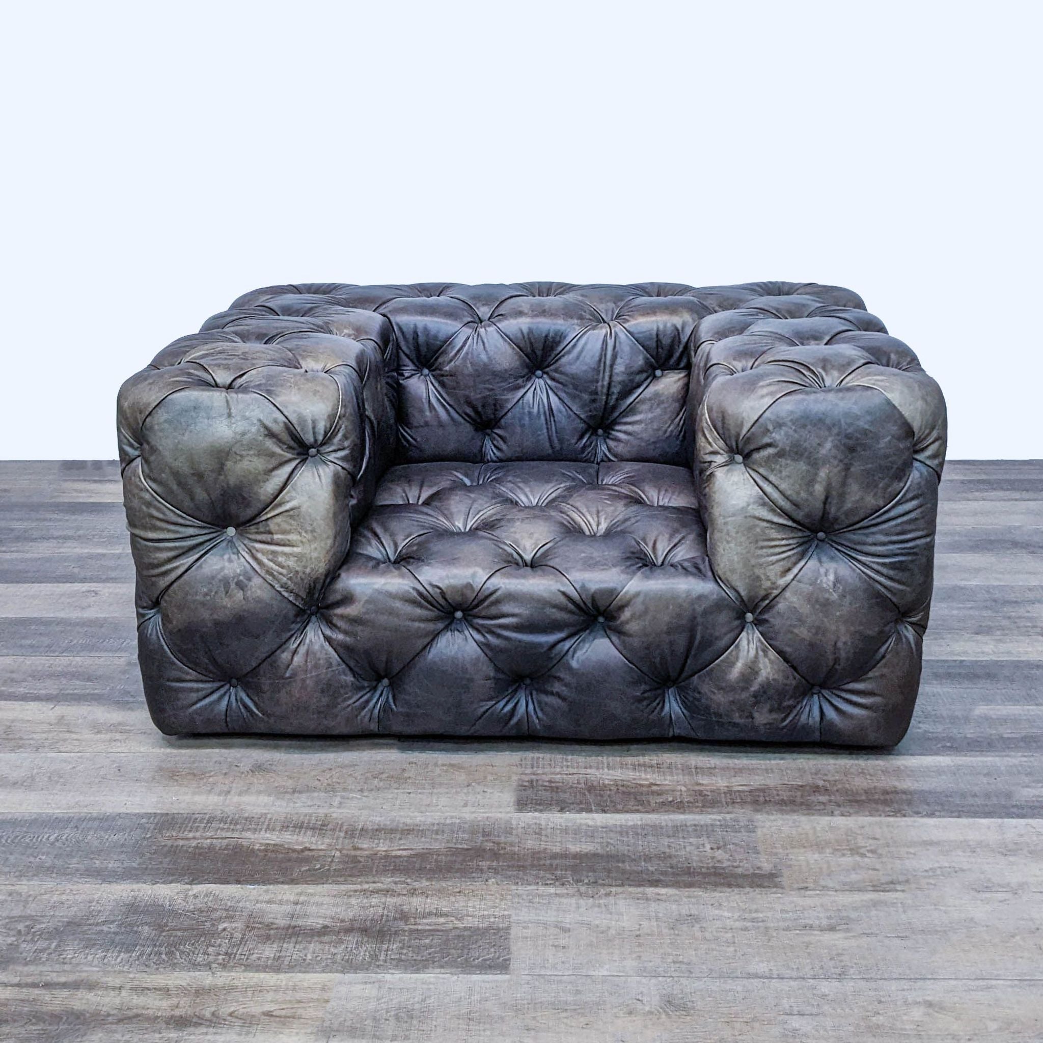 Alt text 1: Restoration Hardware's SoHo club chair with plush, button-tufted upholstery in a dark leather, showcasing its Chesterfield design and low seat profile.