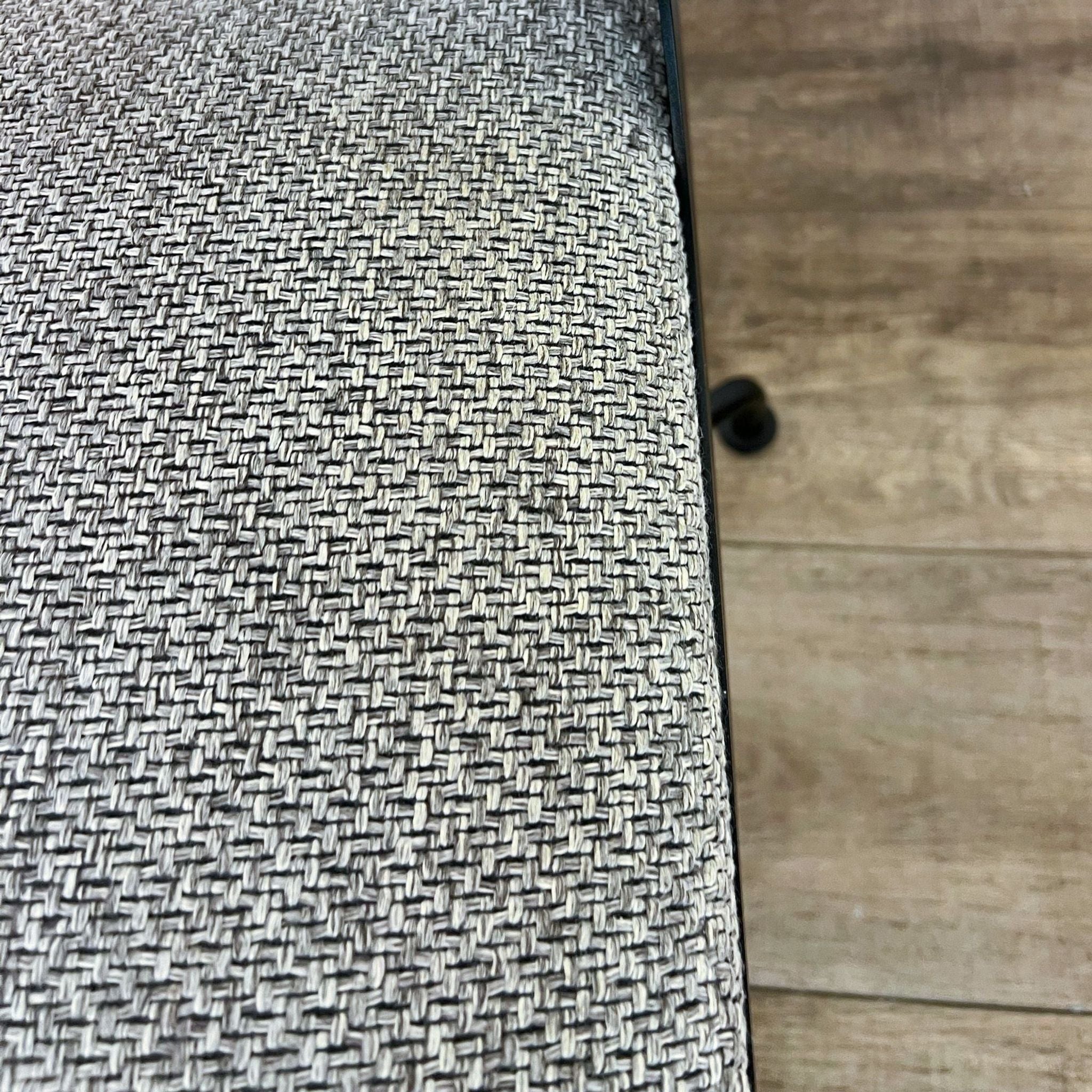 Close-up of the gray tweed upholstery of CB2 Rue Cambon office chair with a glimpse of the black swivel base.