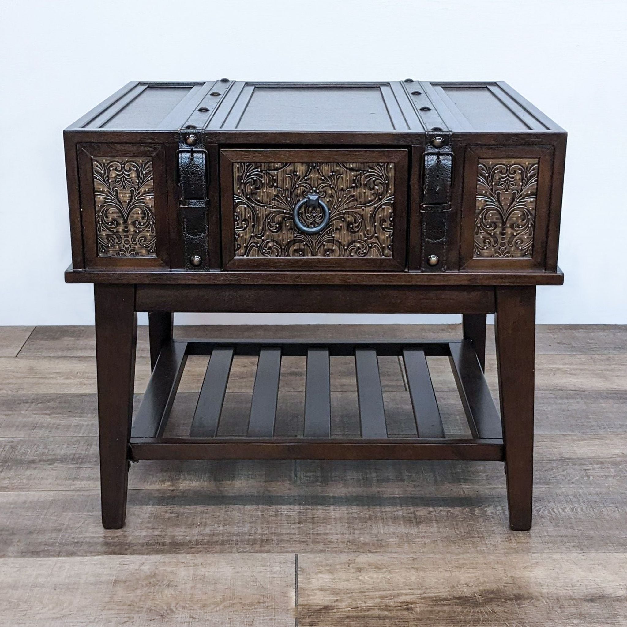 Reperch-brand end table with decorative drawer fronts, leather straps, and a slatted shelf on a wooden floor.