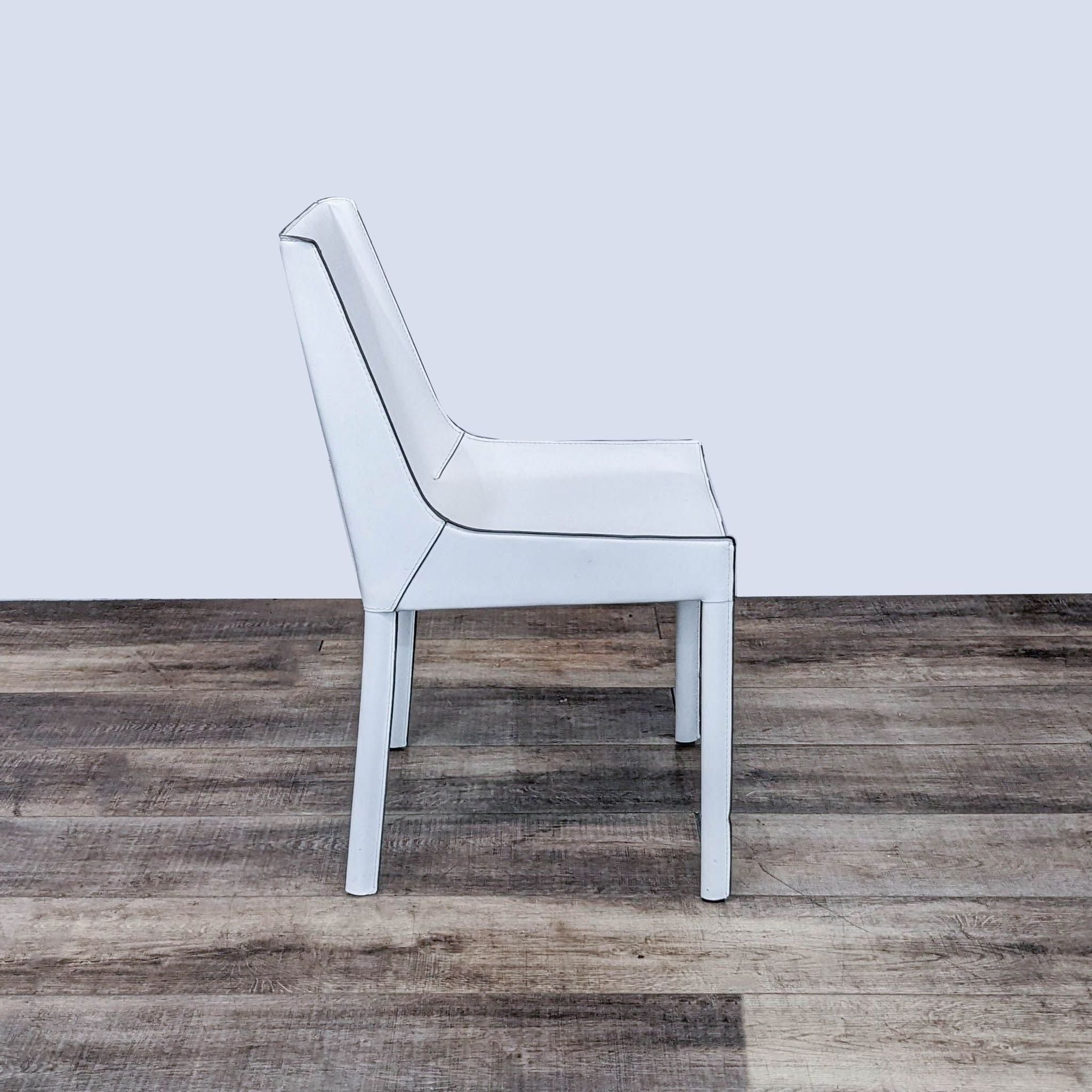 Contemporary white Fashion dining chair by Zuo Modern, featuring recycled leather upholstery and a sleek profile on a wooden floor.