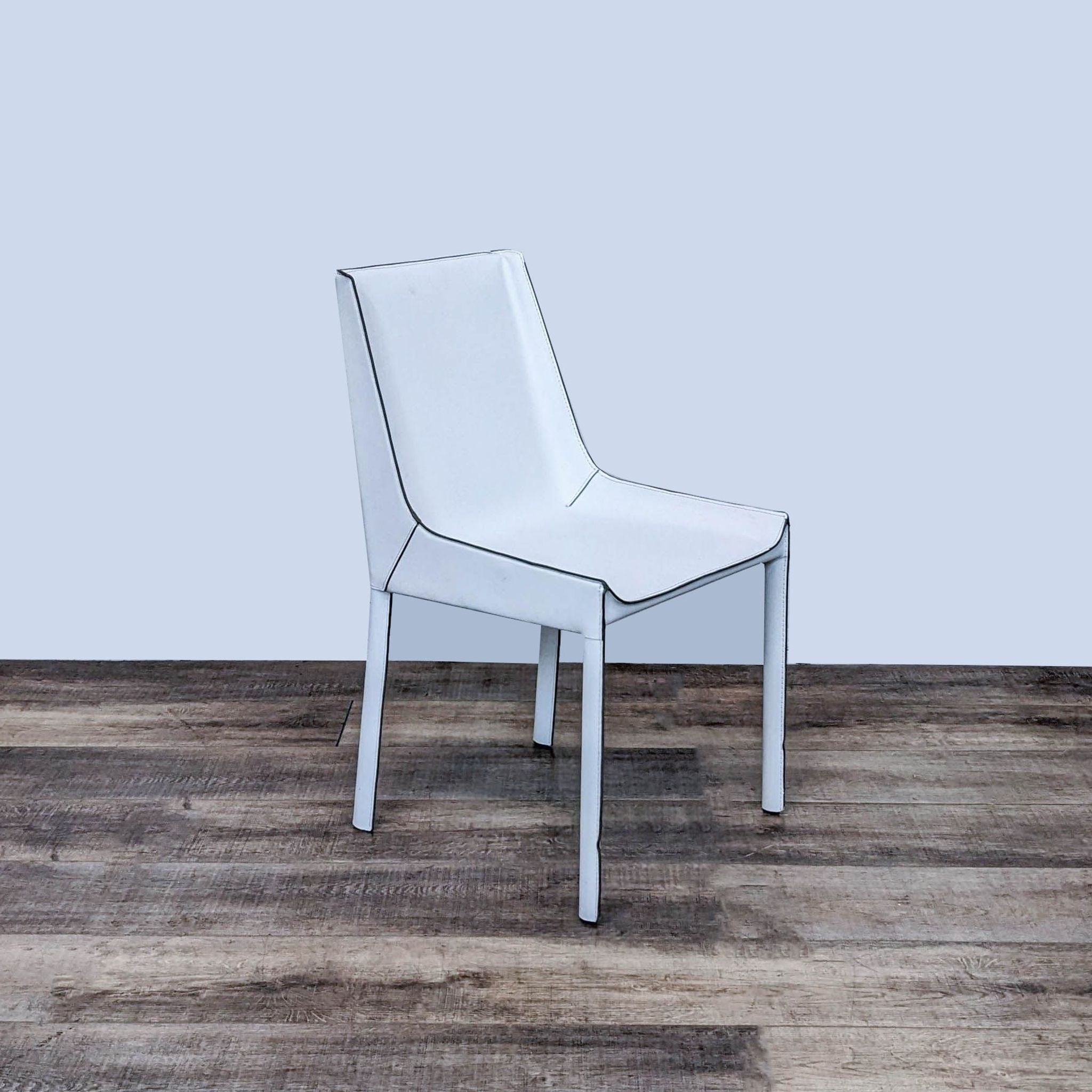 Contemporary Zuo Modern Fashion dining chair with a slim profile, upholstered in white recycled leather on a wooden floor.