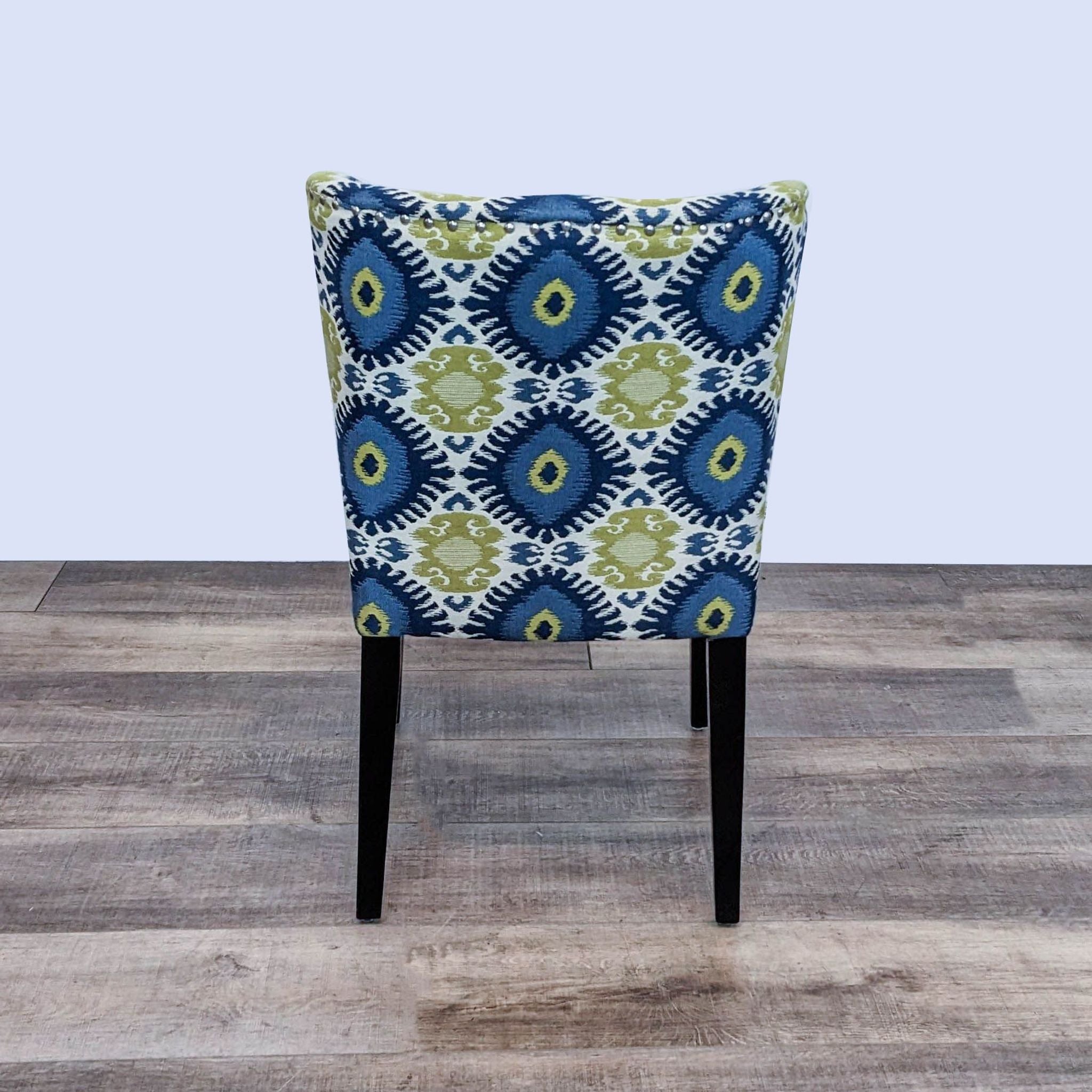Cost Plus dining chair with Ikat fabric upholstery and black tapered wooden legs.