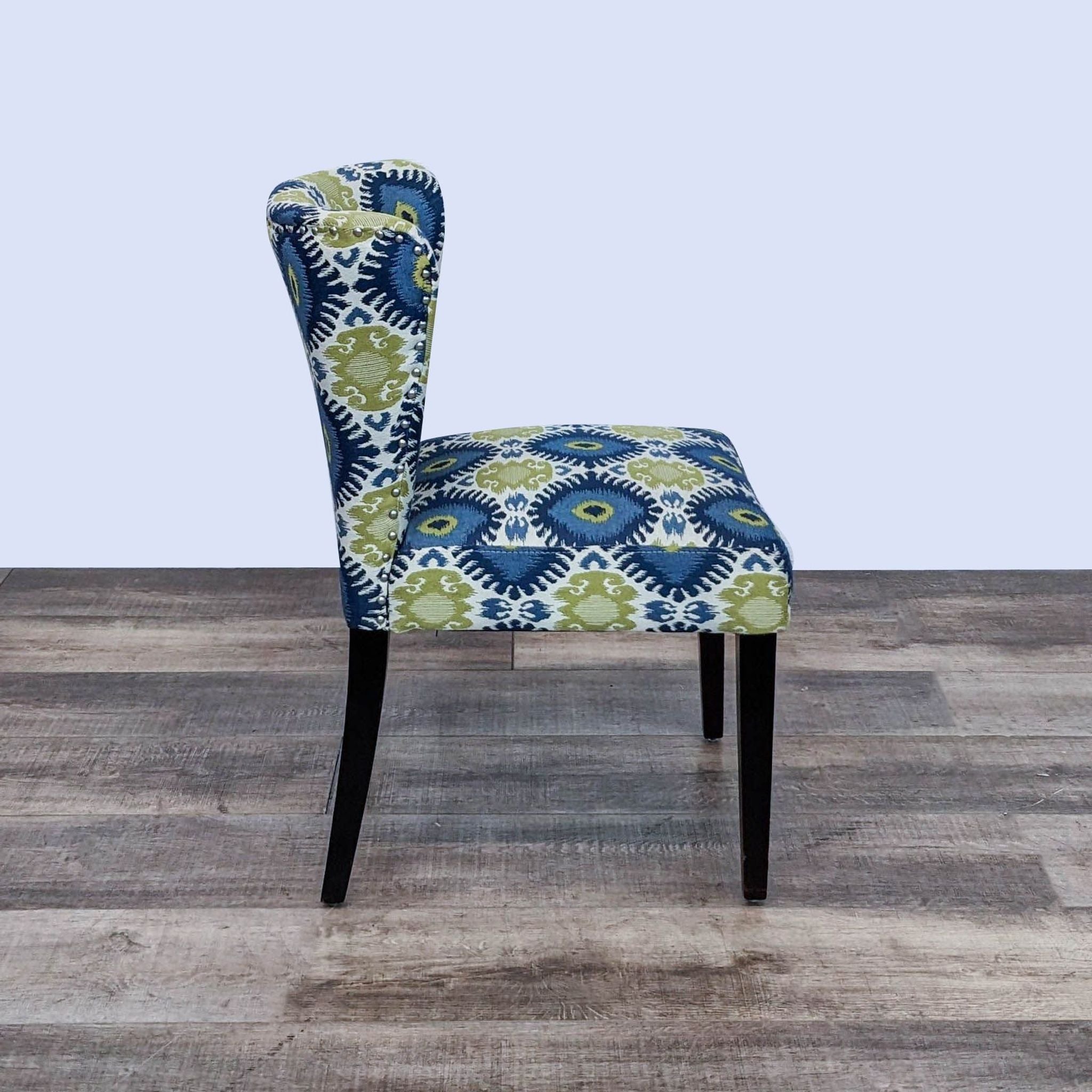 Cost Plus dining chair with colorful Ikat upholstery and black wooden legs, angled view.