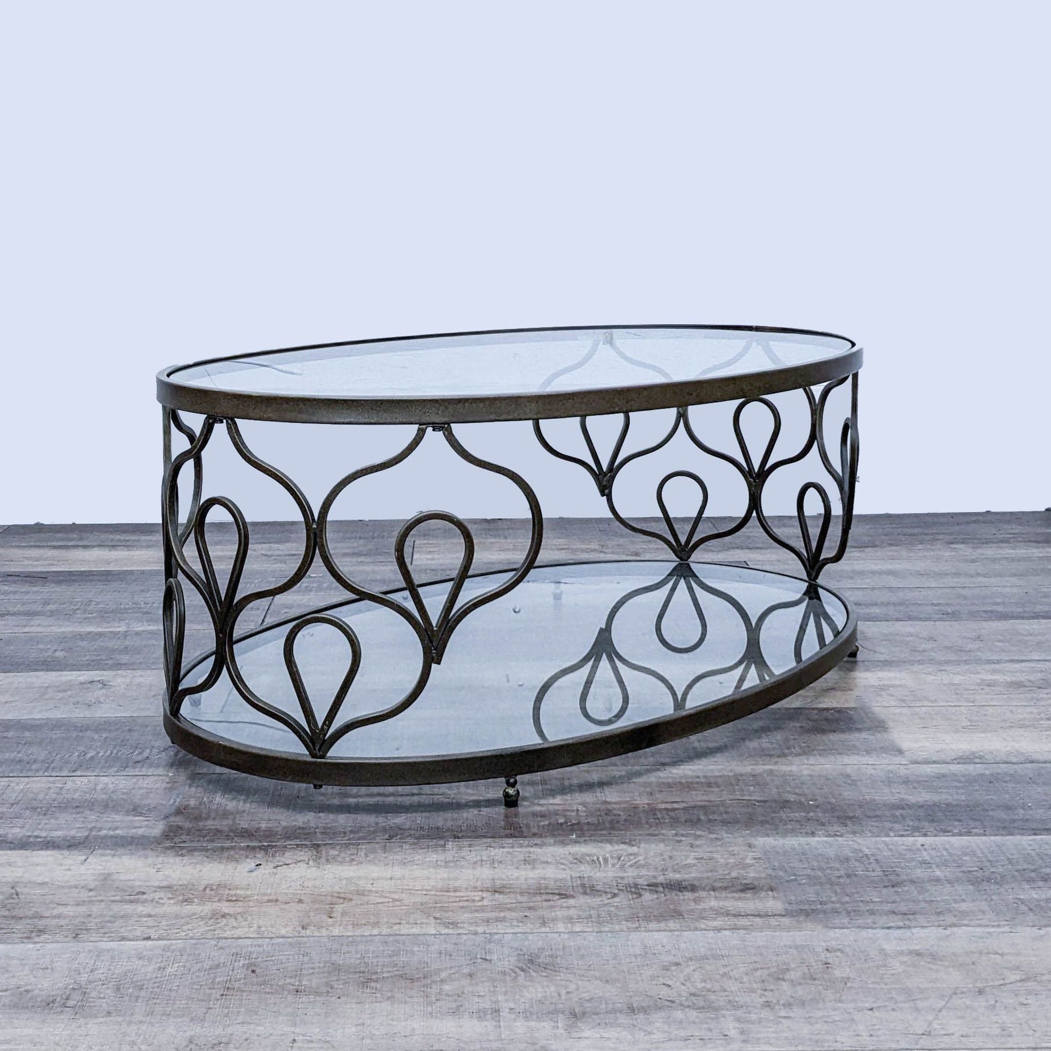 2. Elegant Reperch coffee table featuring a glass top and ornamental metal framework, set on a wood-textured surface.