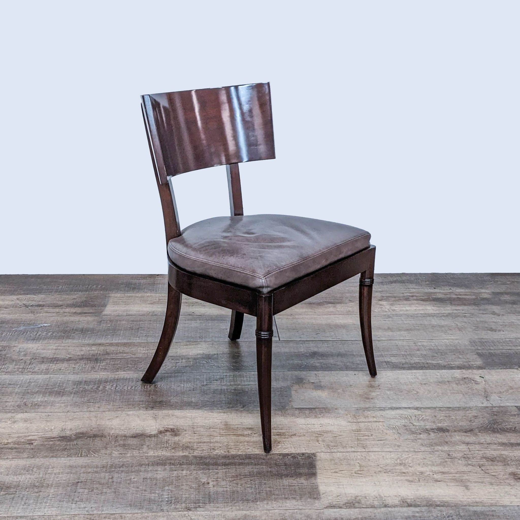 Williams Sonoma Home dining chair with wood scoop back and leather upholstered seat, on wooden floor.