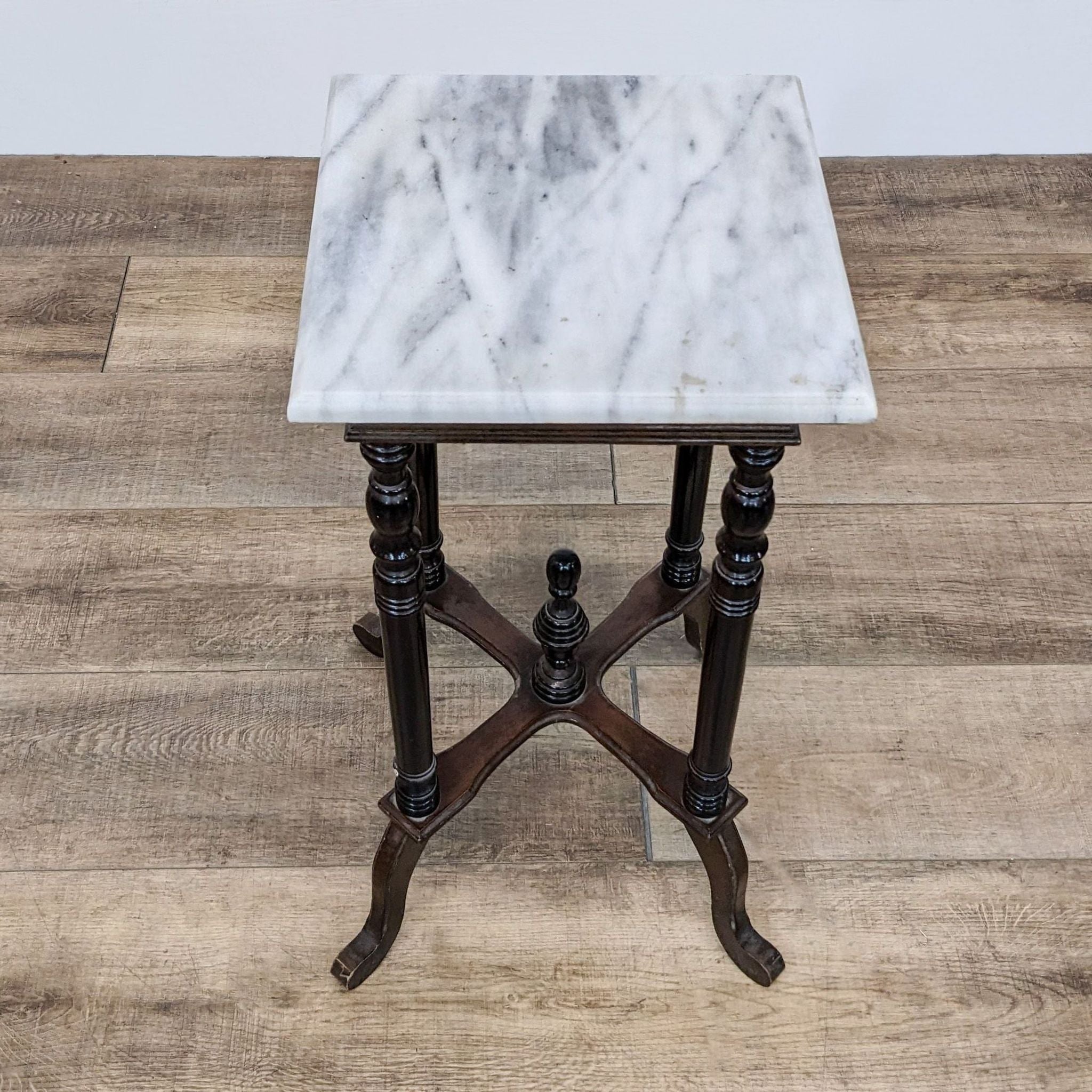 Elegant Reperch console table featuring a marble surface and ornate wood legs with finial.