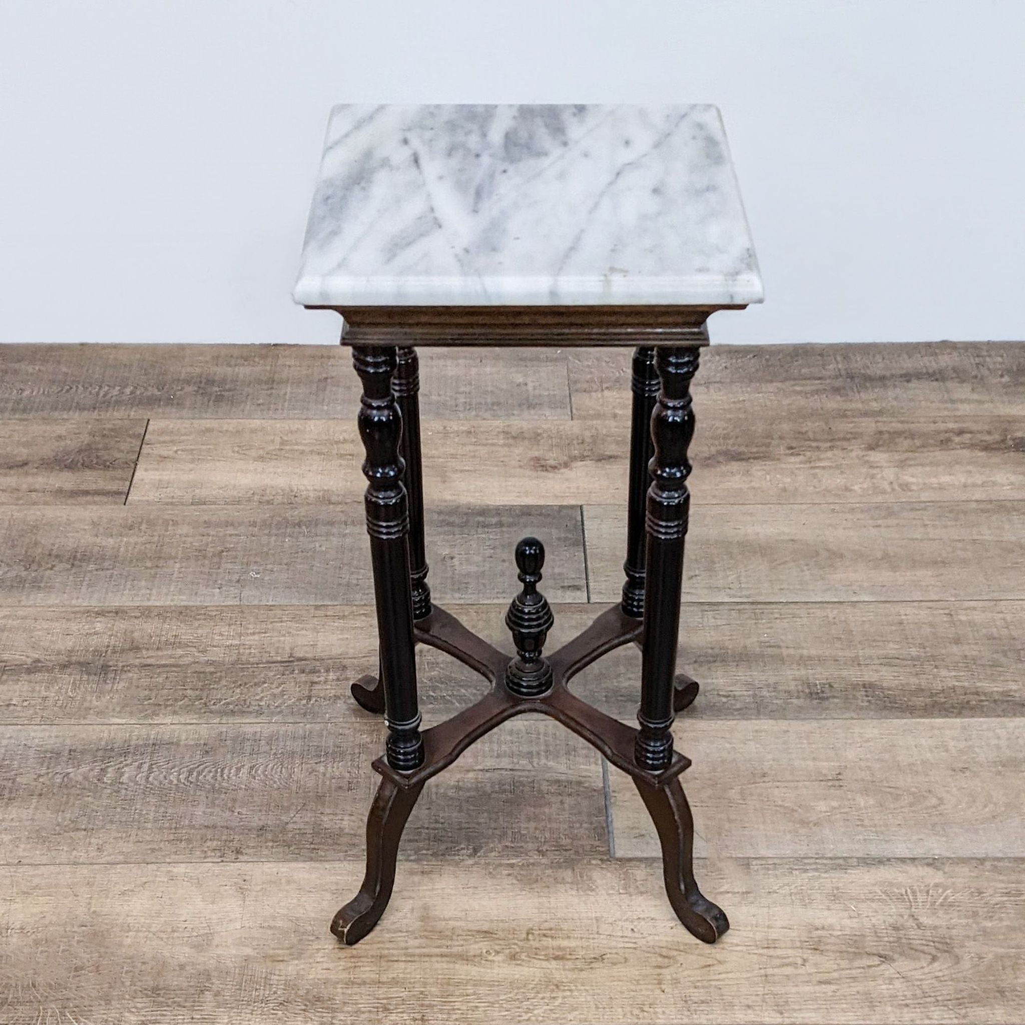 Reperch branded side table featuring a marble top and ornate turned wood legs on a wooden floor.