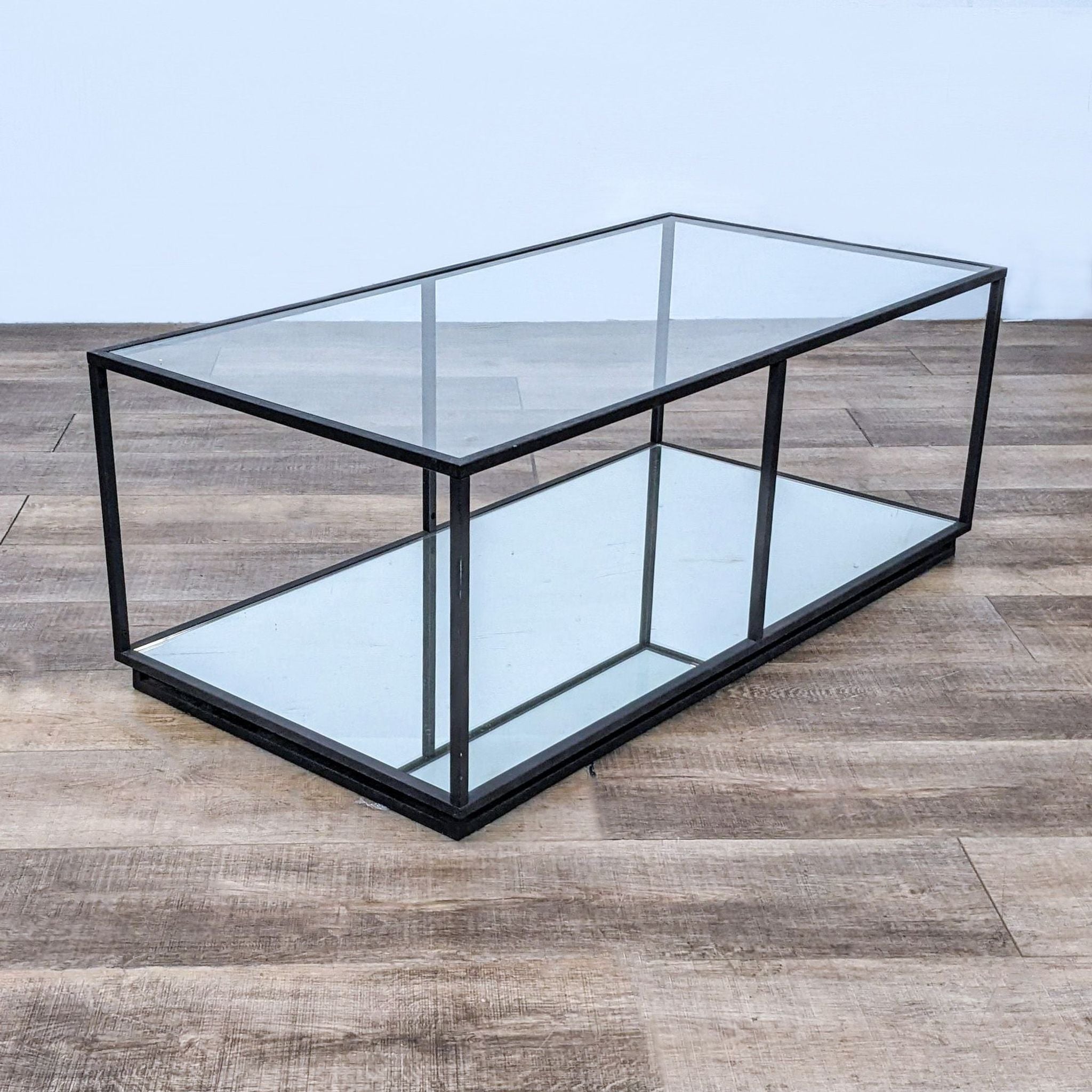 Reperch metal box frame coffee table with glass top and lower shelf on wooden floor.