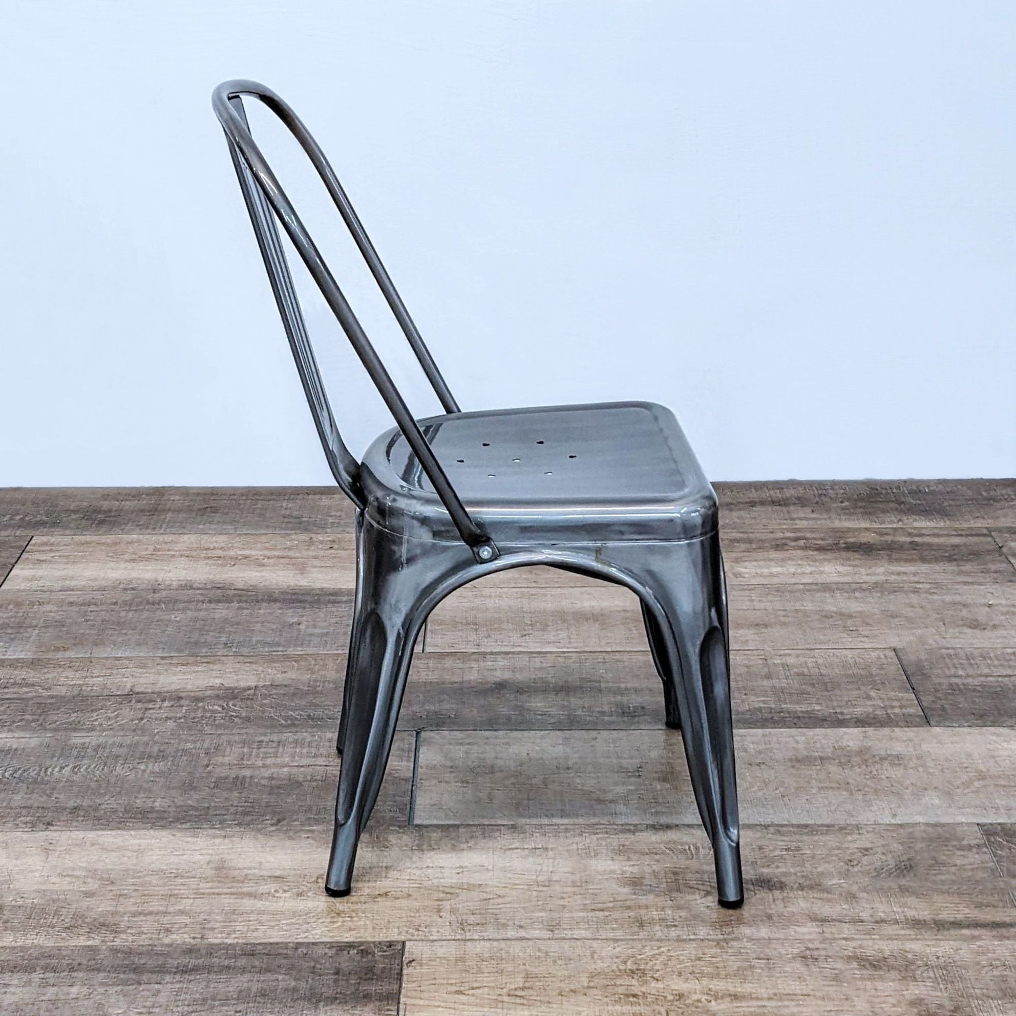 Stackable Reperch industrial dining chair, metal construction, compact and lightweight, shown from an angle.