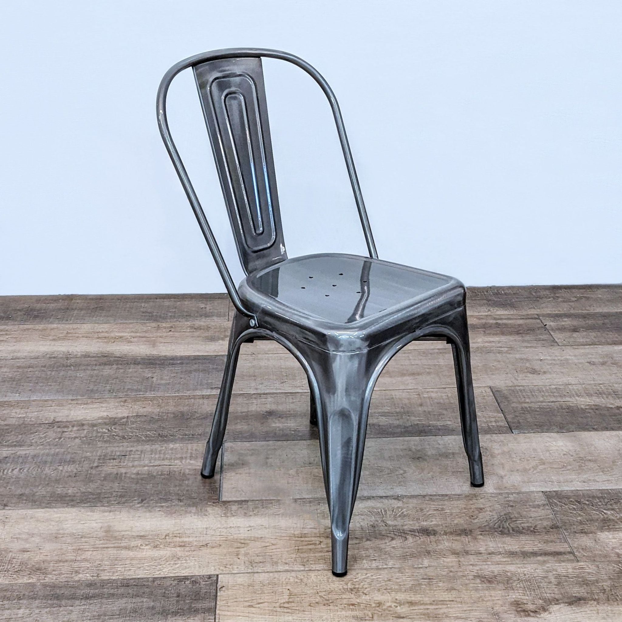 Reperch brand industrial metal side chair with a curved back and tapered legs suitable for indoor or outdoor seating.