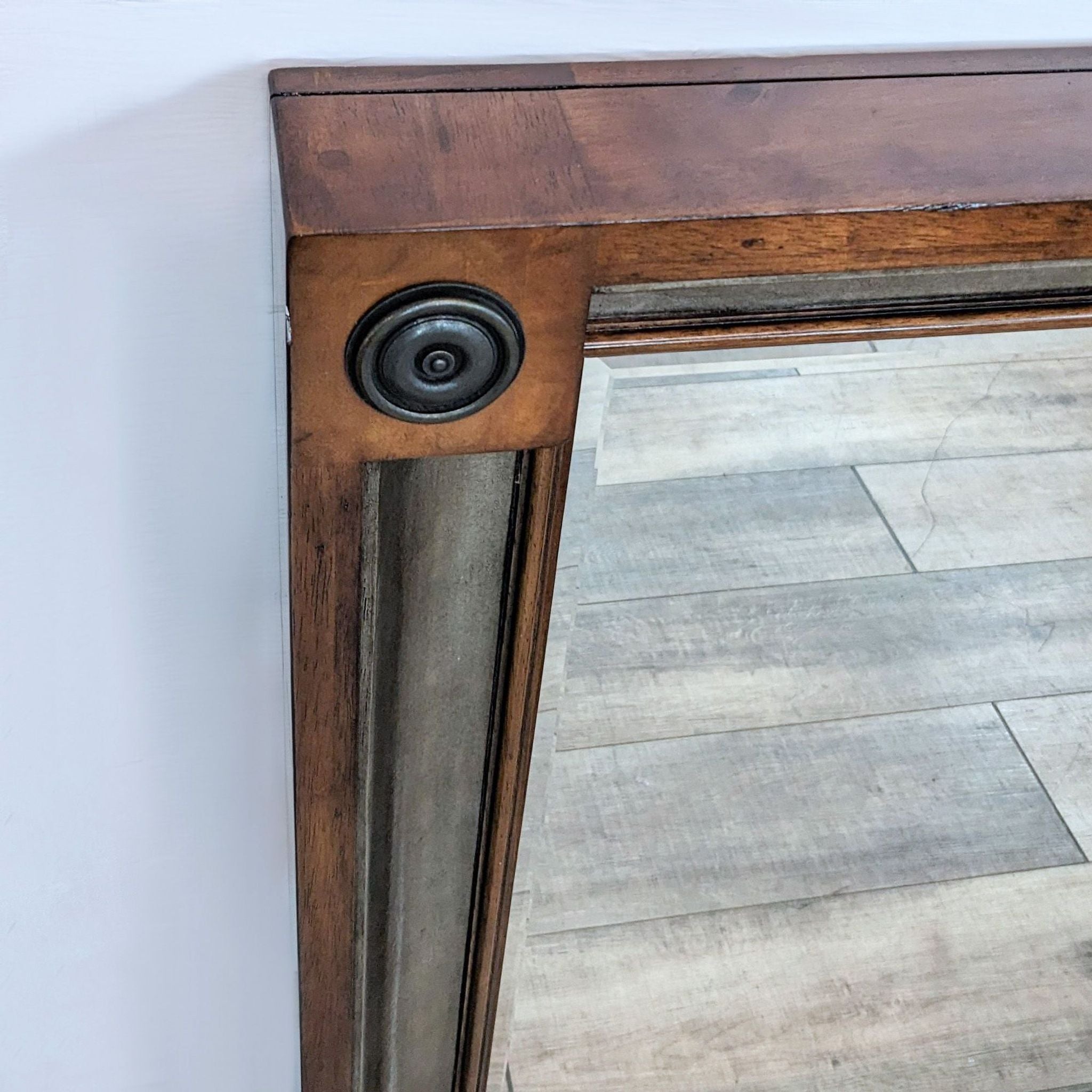 Close-up of a Bernhardt Furniture wall mirror showing the detailed bullseye corners and the wood's dark stain.