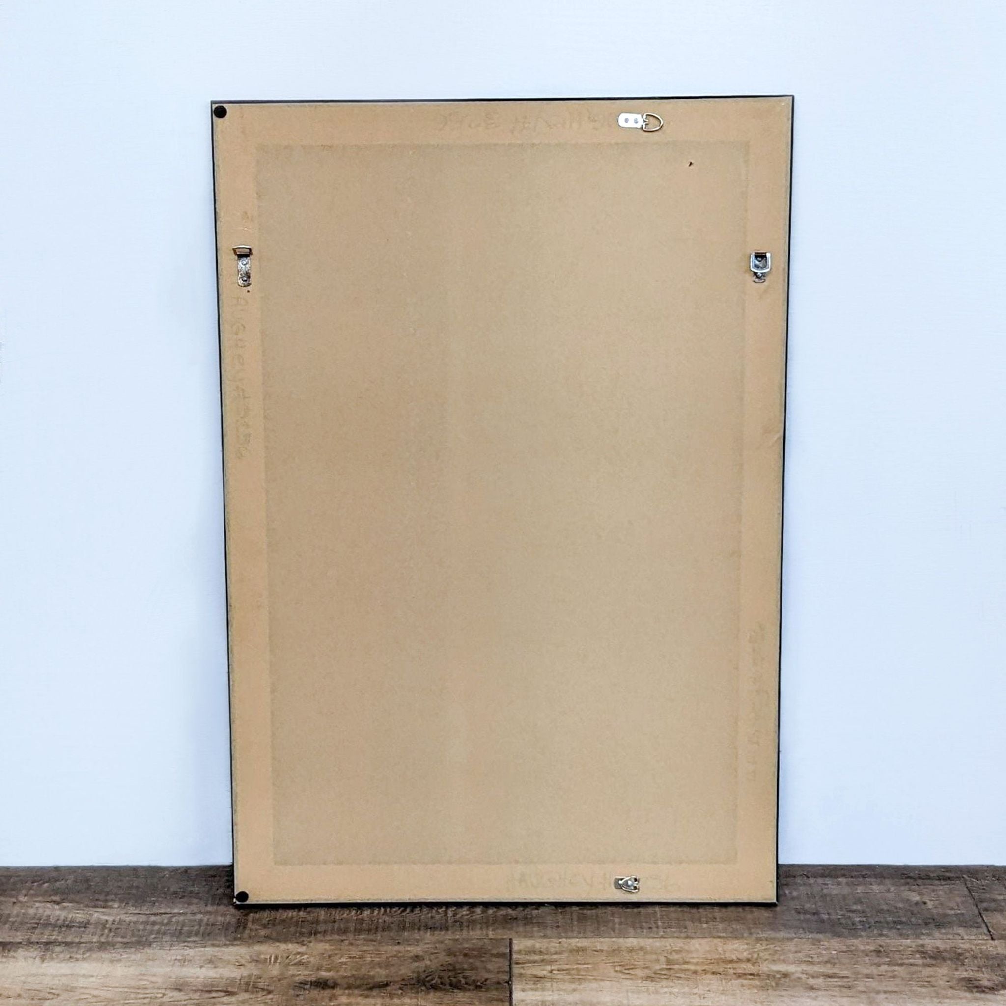 Rear view of Reperch wall mirror with brown backing, metal mounts, and label.