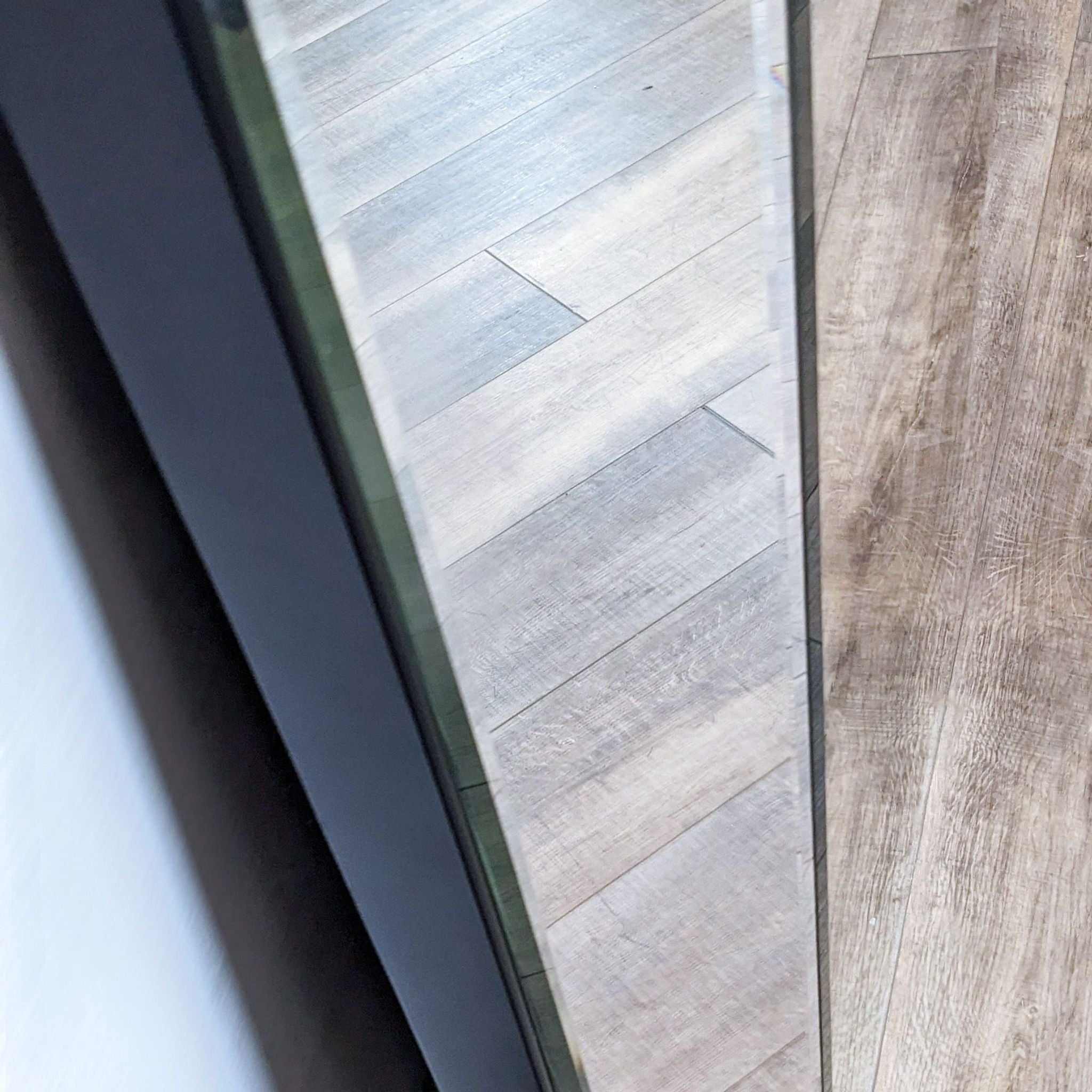 Alt text 2: Close-up of Williams Sonoma Home mirror's beveled edge detail and wooden flooring reflected in its surface.