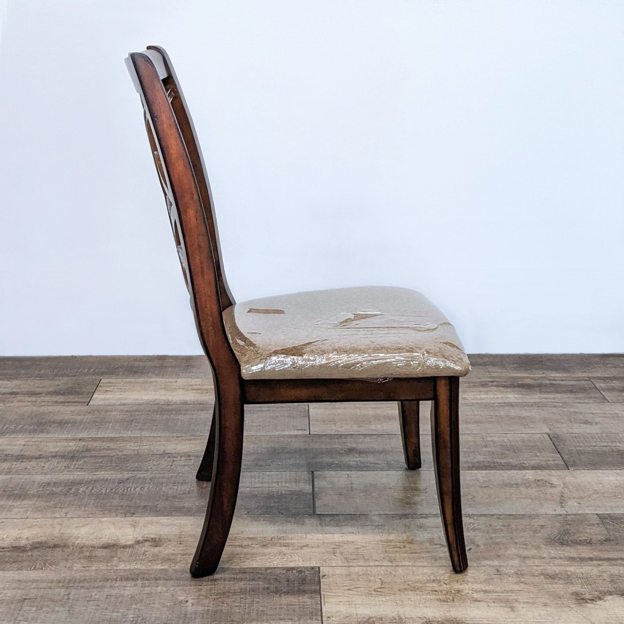 Side view of Reperch dining chair with dark wood frame and beige upholstered seat.