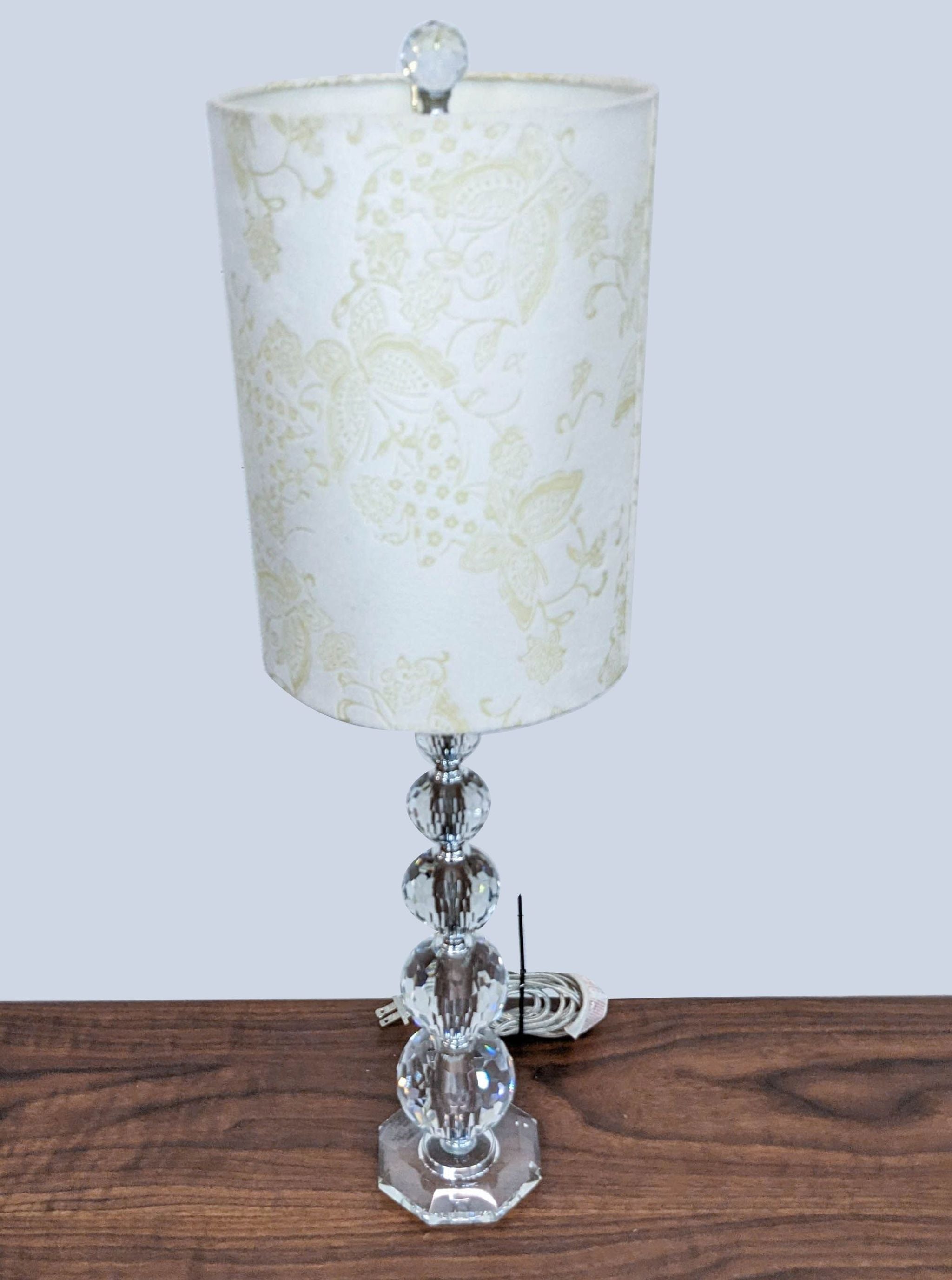Reperch brand table lamp with floral-patterned shade and crystal base on wooden surface.