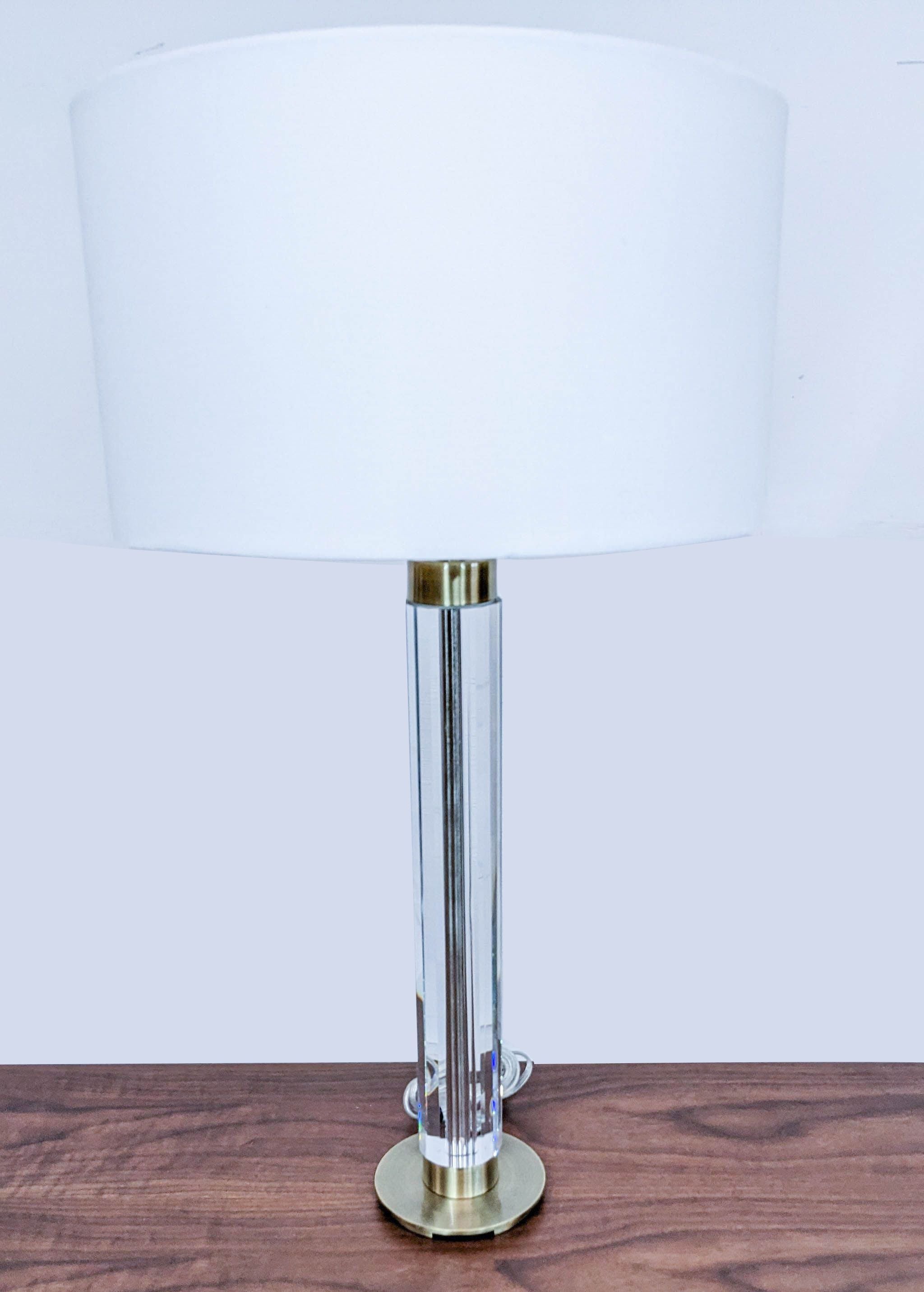 Reperch brand modern table lamp with white shade and clear cylindrical body on wooden surface.