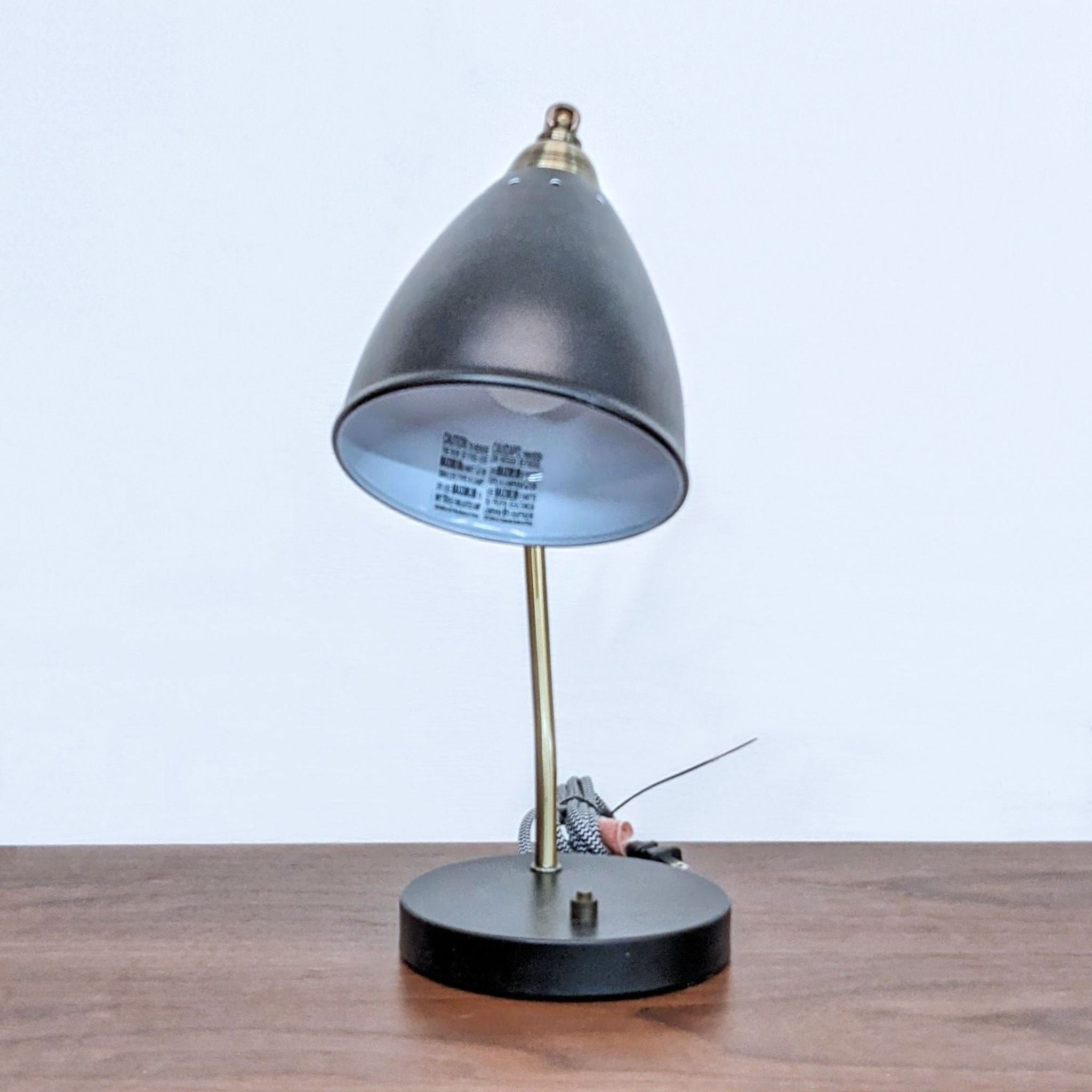 Modern black and gold Arcadia Collection task lamp on desk, showcasing different angles.
