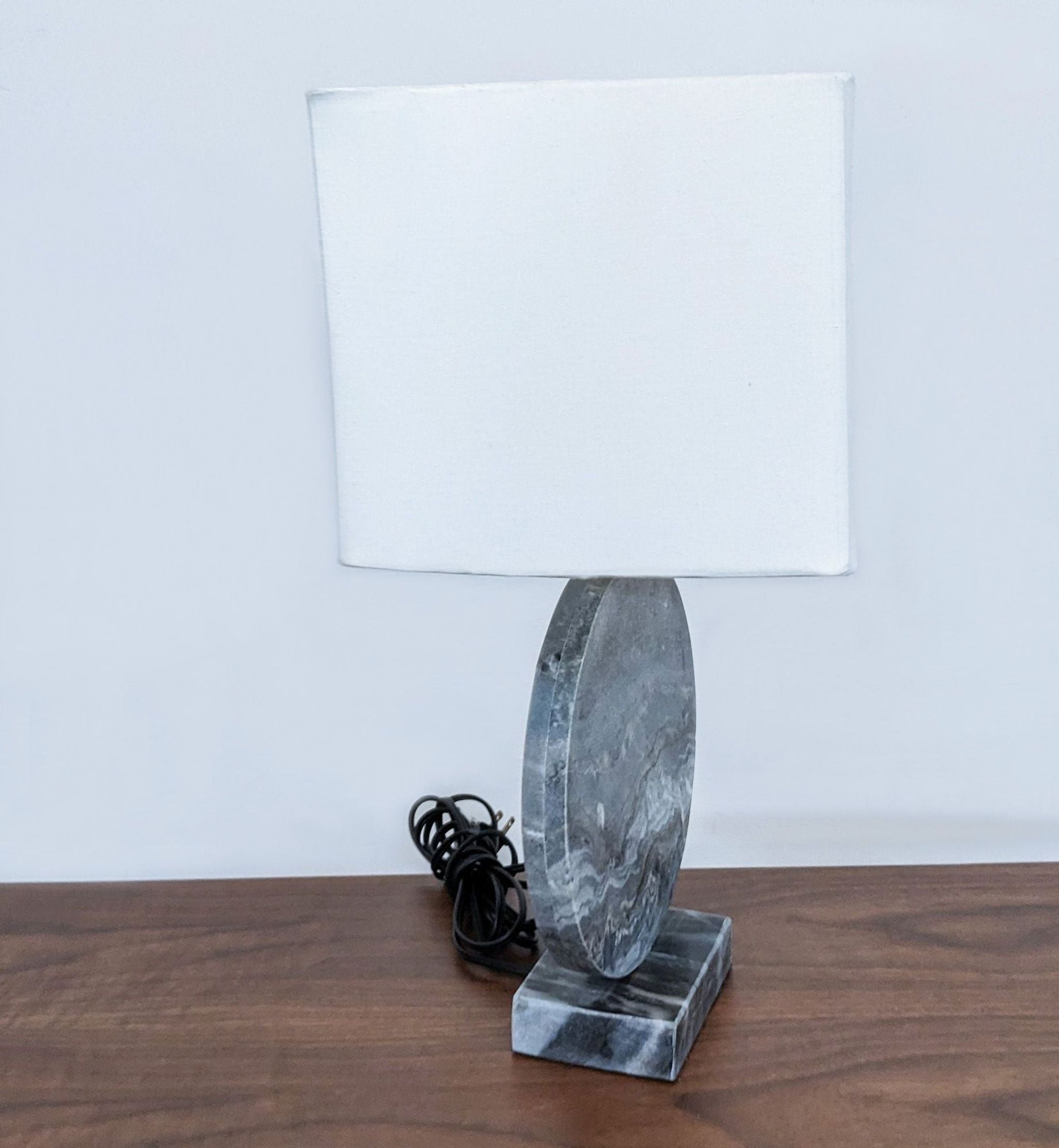 Marble-patterned Reperch table lamp with a white fabric shade, visible cord, displayed on a wood tabletop.