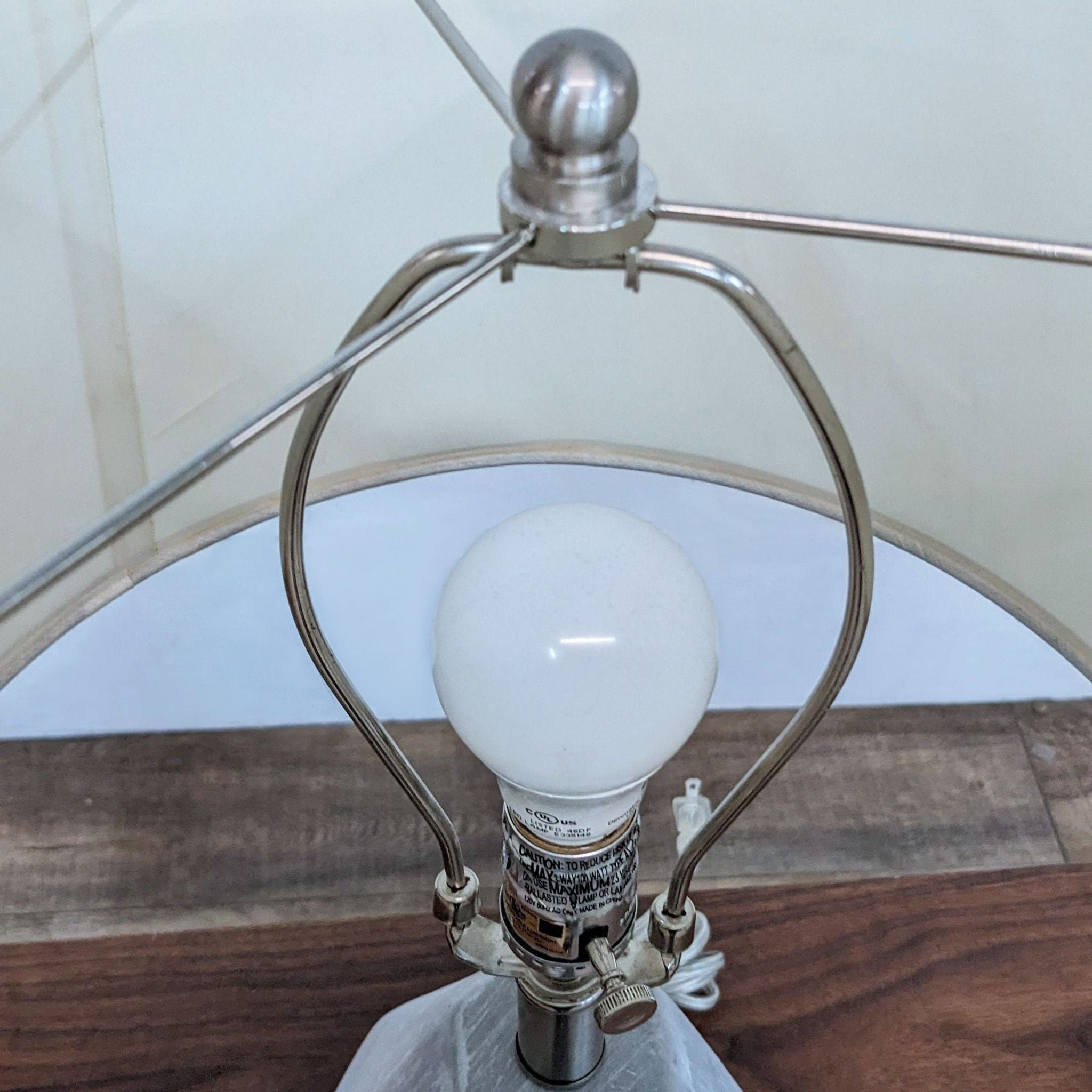 Alt text 2: Close-up of a Surya table lamp showing the bulb and metal frame beneath the shade, with label visible on the mount.