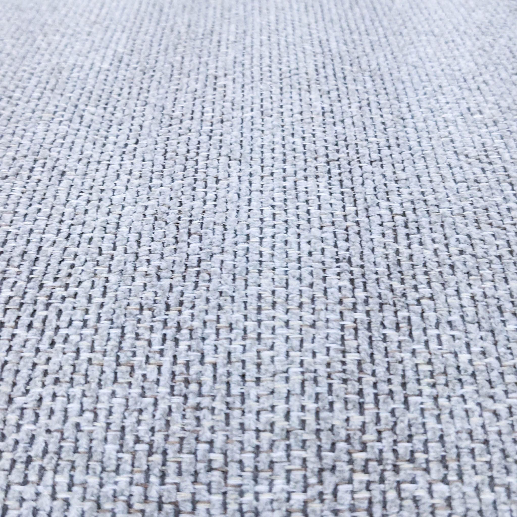 Alt text 2: Close-up of the woven fabric texture on a large, square, neutral-colored Costco ottoman with dark legs.