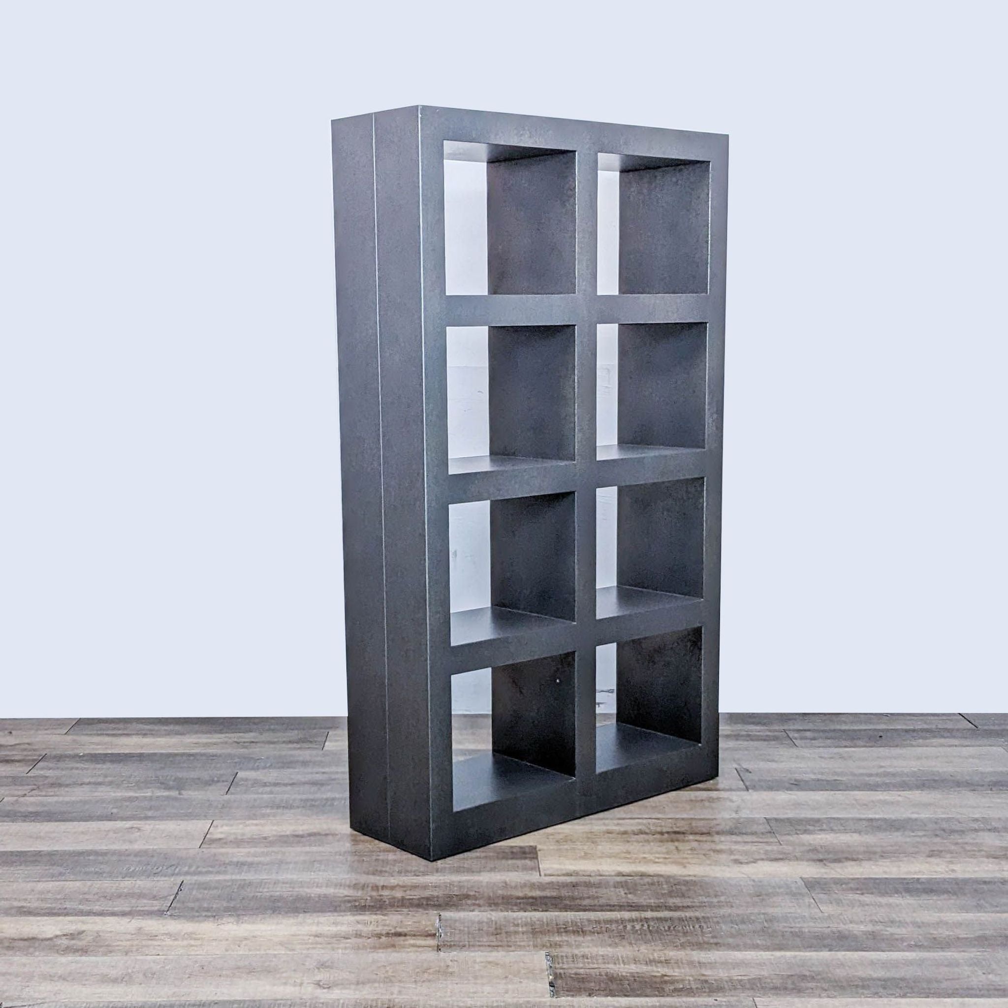 Crate and Barrel modern steel bookcase with a graphite finish, displayed in angled view against a plain backdrop.