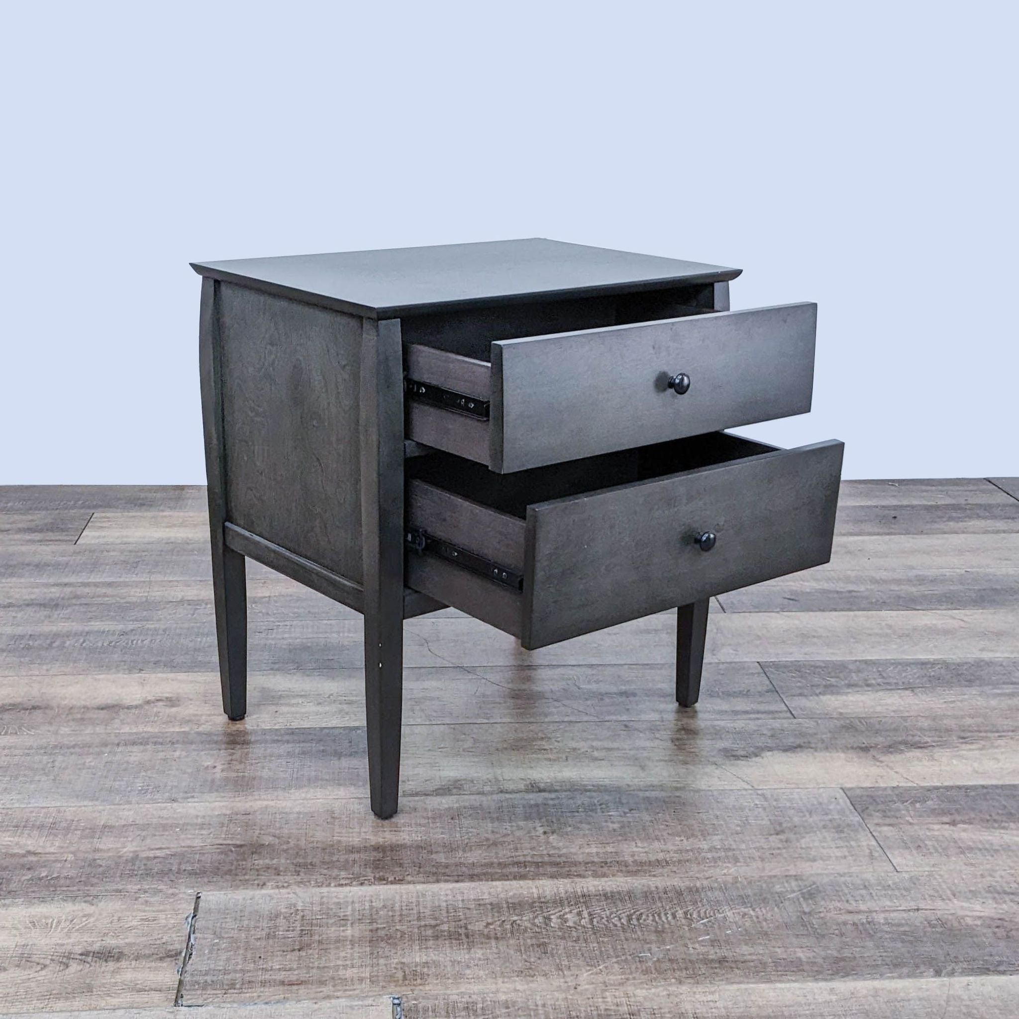 Alt text 2: Open drawer view of a birch veneer end table with round graphite-finished pulls, showcasing storage space, by Crate & Barrel.