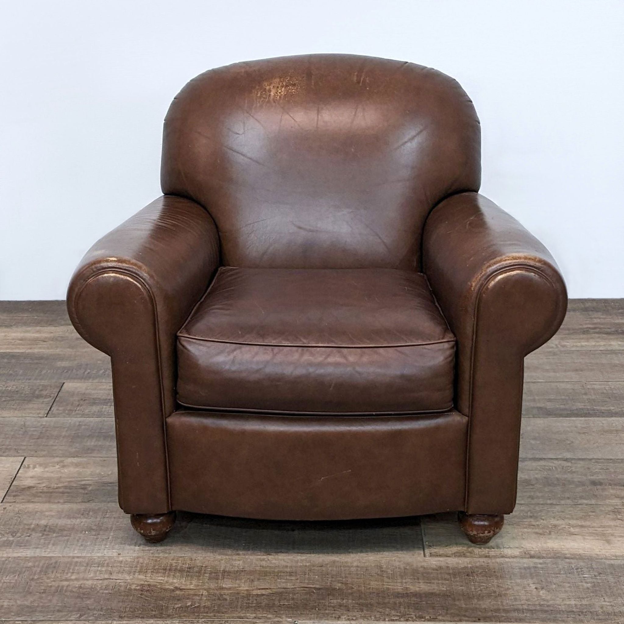 Reperch brand leather club chair with rolled arms, wooden feet, and a comfortable deep seat.