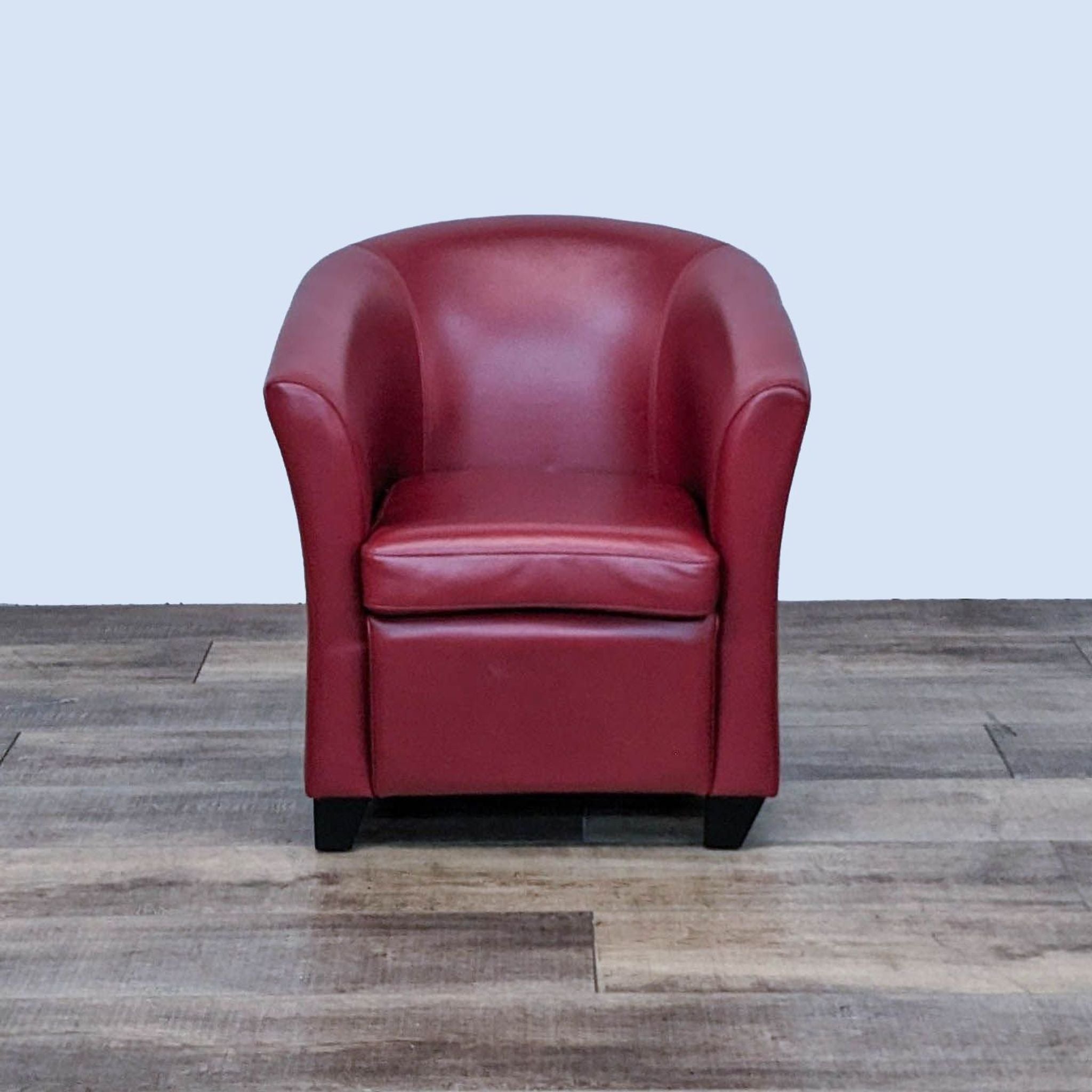 Reperch Art Deco style red leather tub chair, front view, with tapered wooden feet on a wooden floor.