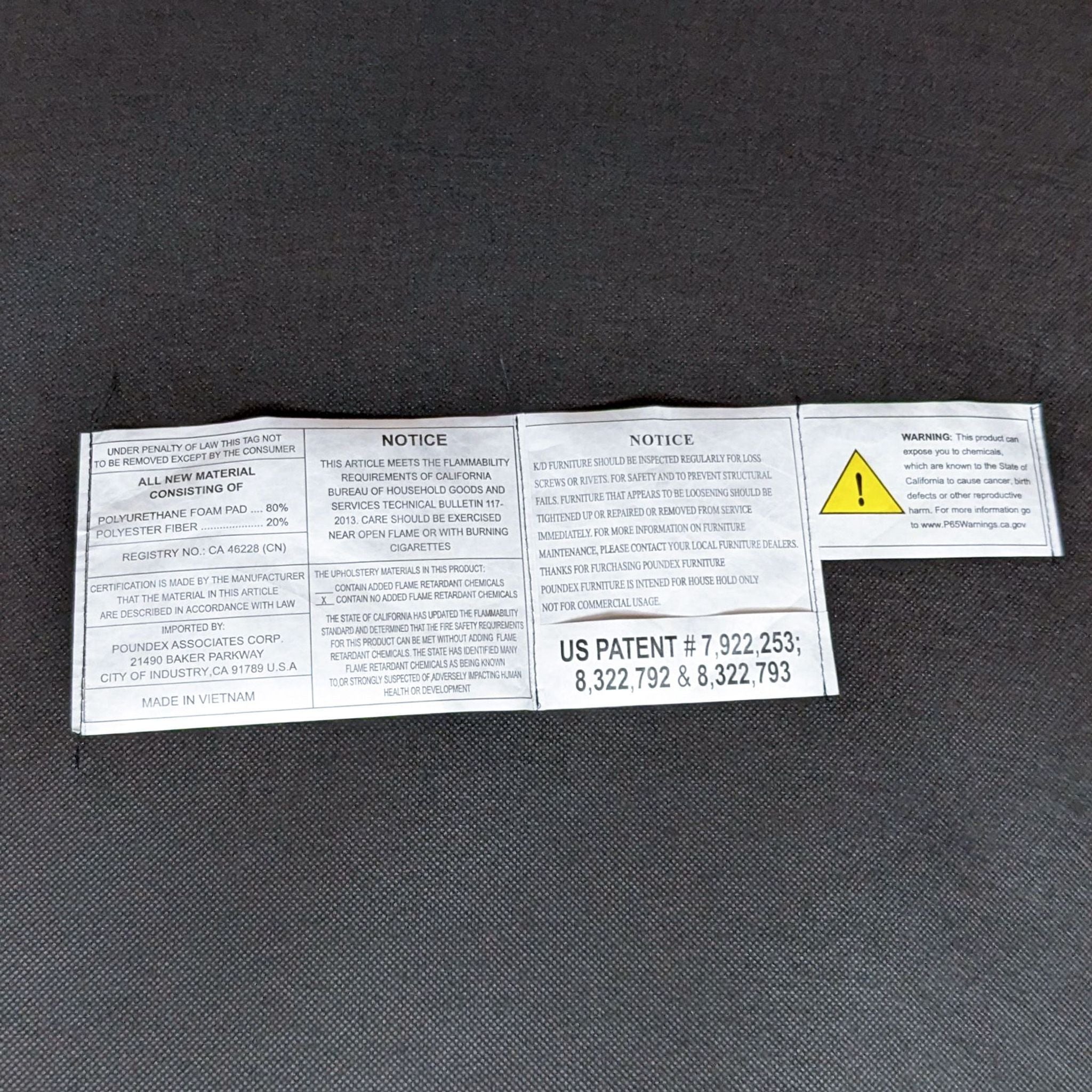 Tags and warning labels on gray fabric of a Reperch sectional, indicating material composition, safety notices, and patents.
