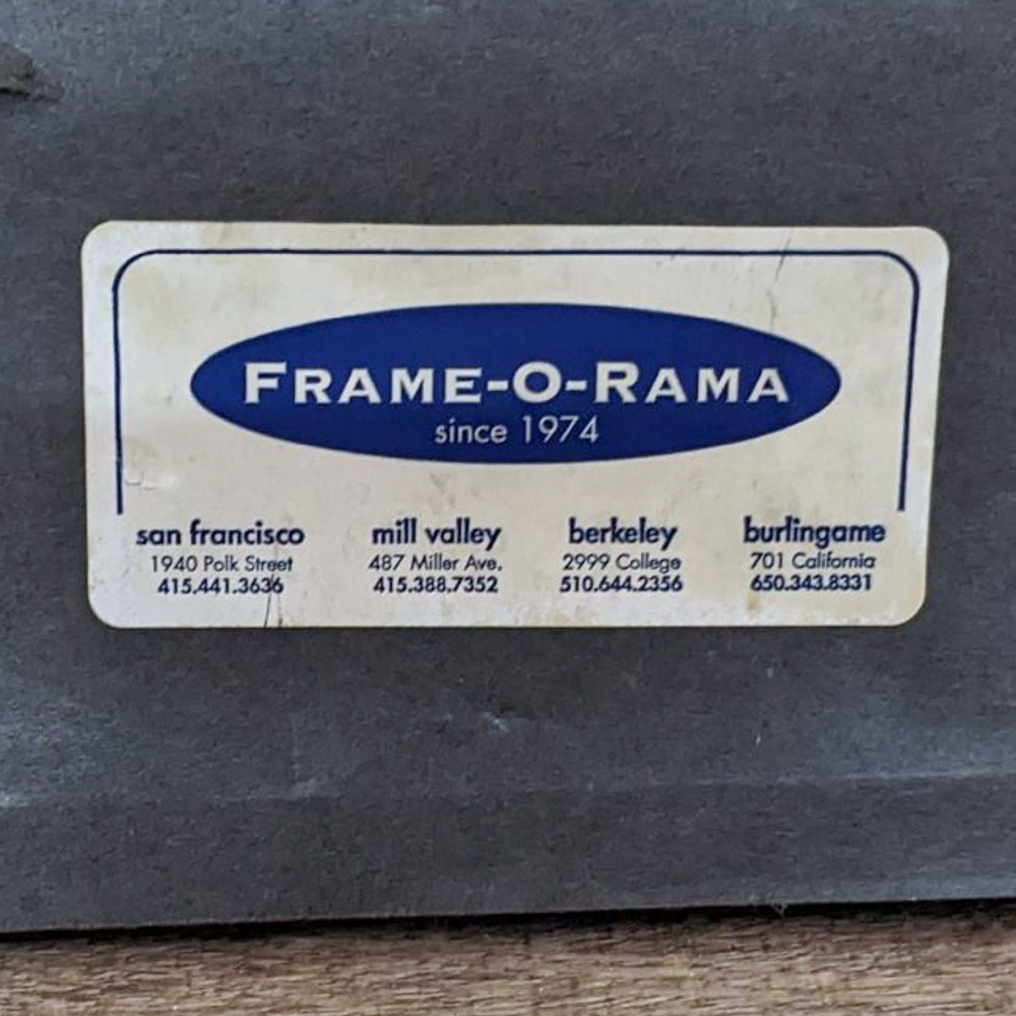 Label from FRAME-O-RAMA on a picture frame listing multiple locations and contact numbers.