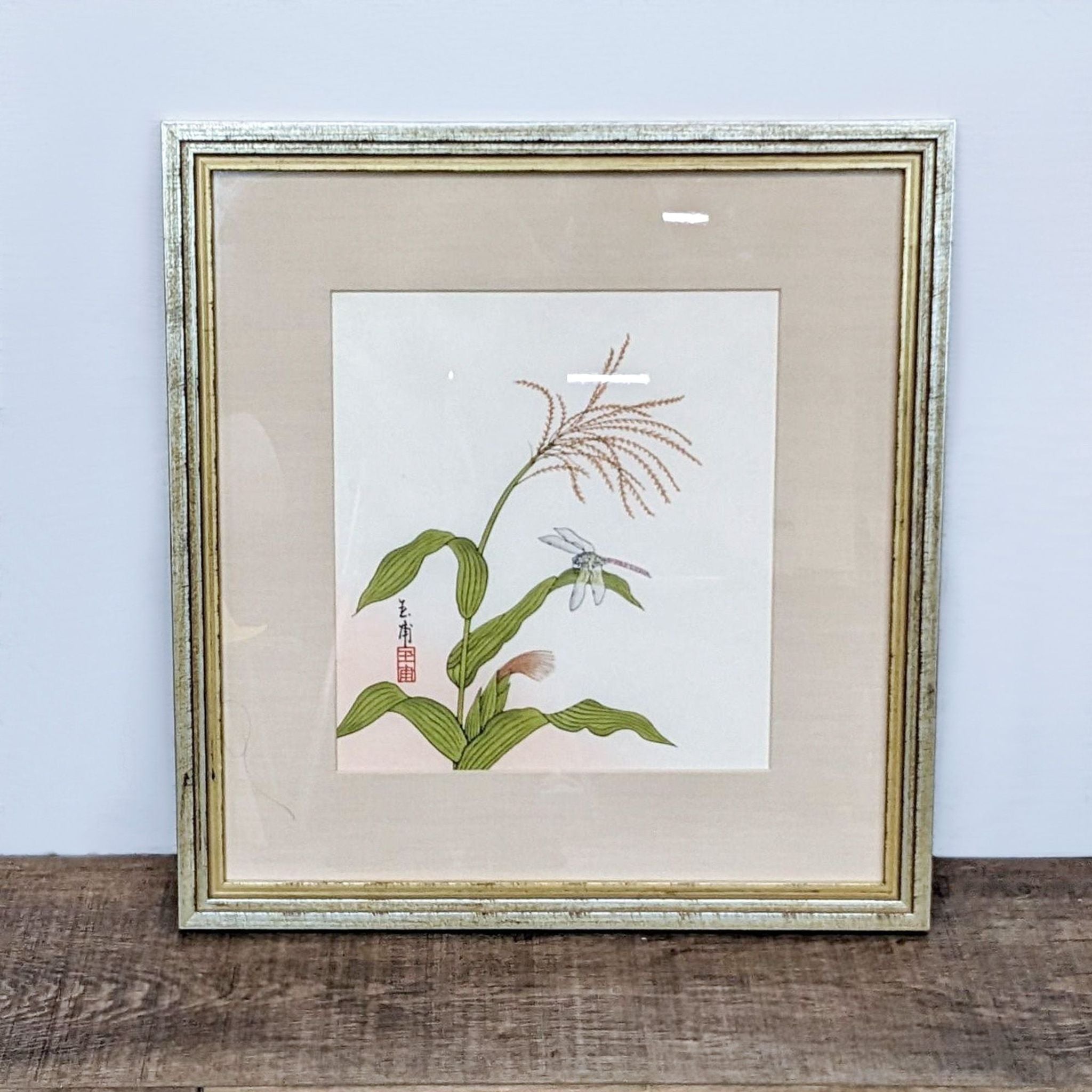 Botanical print with delicate plant and dragonfly, featuring Asian calligraphy, encased in a gold frame by Reperch.