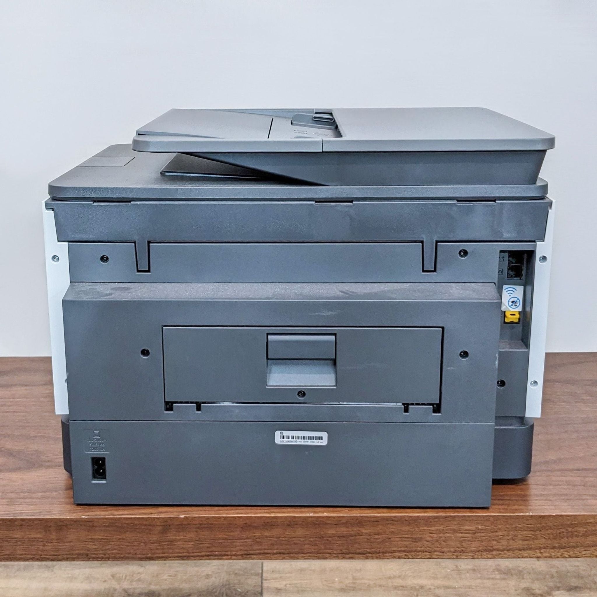 HP All-in-One wireless printer with printing, scanning, and copying functions, featuring a touch screen interface on a wooden desk.