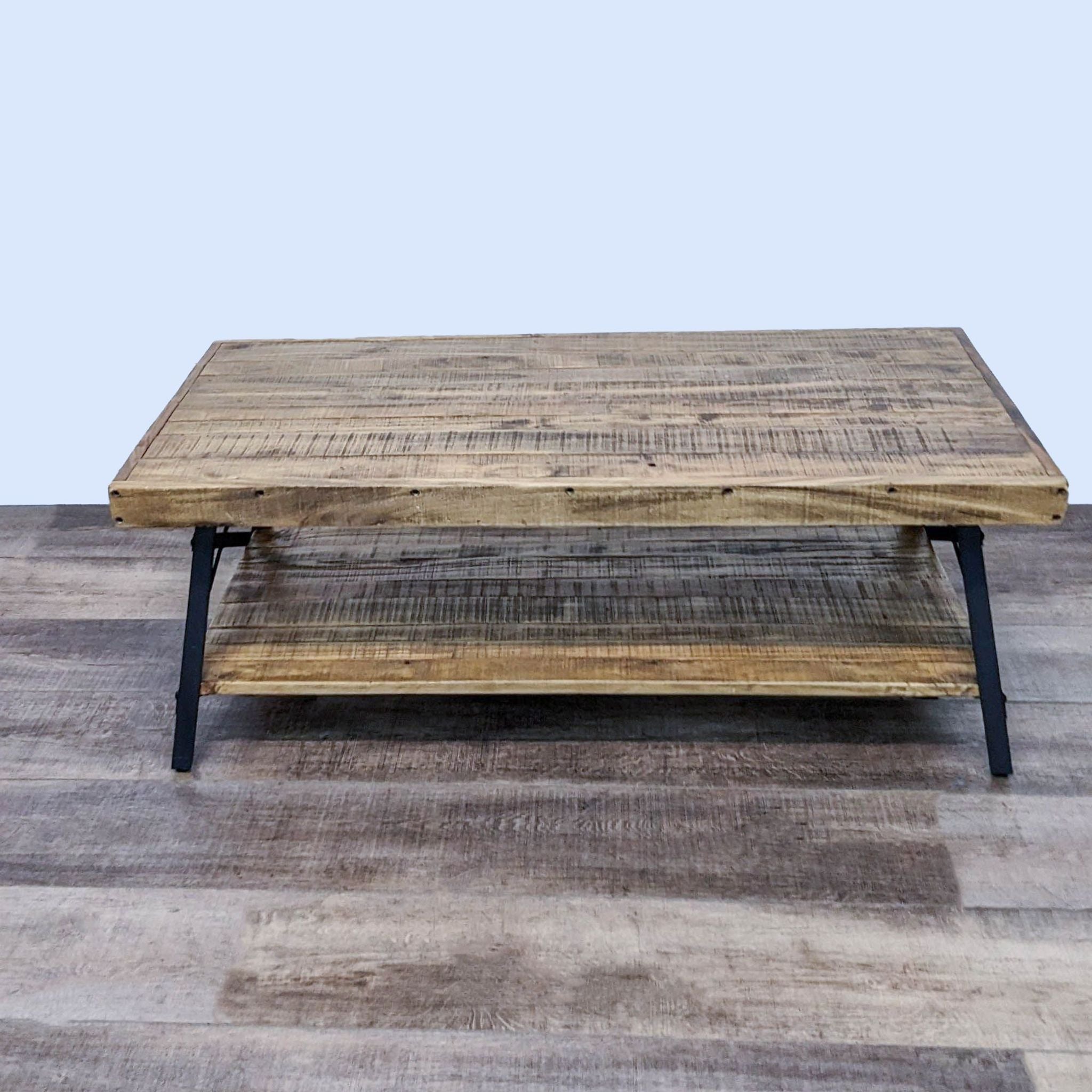 Planked wooden BoConcept coffee table featuring a lower shelf and sturdy metal bracing on a textured floor.