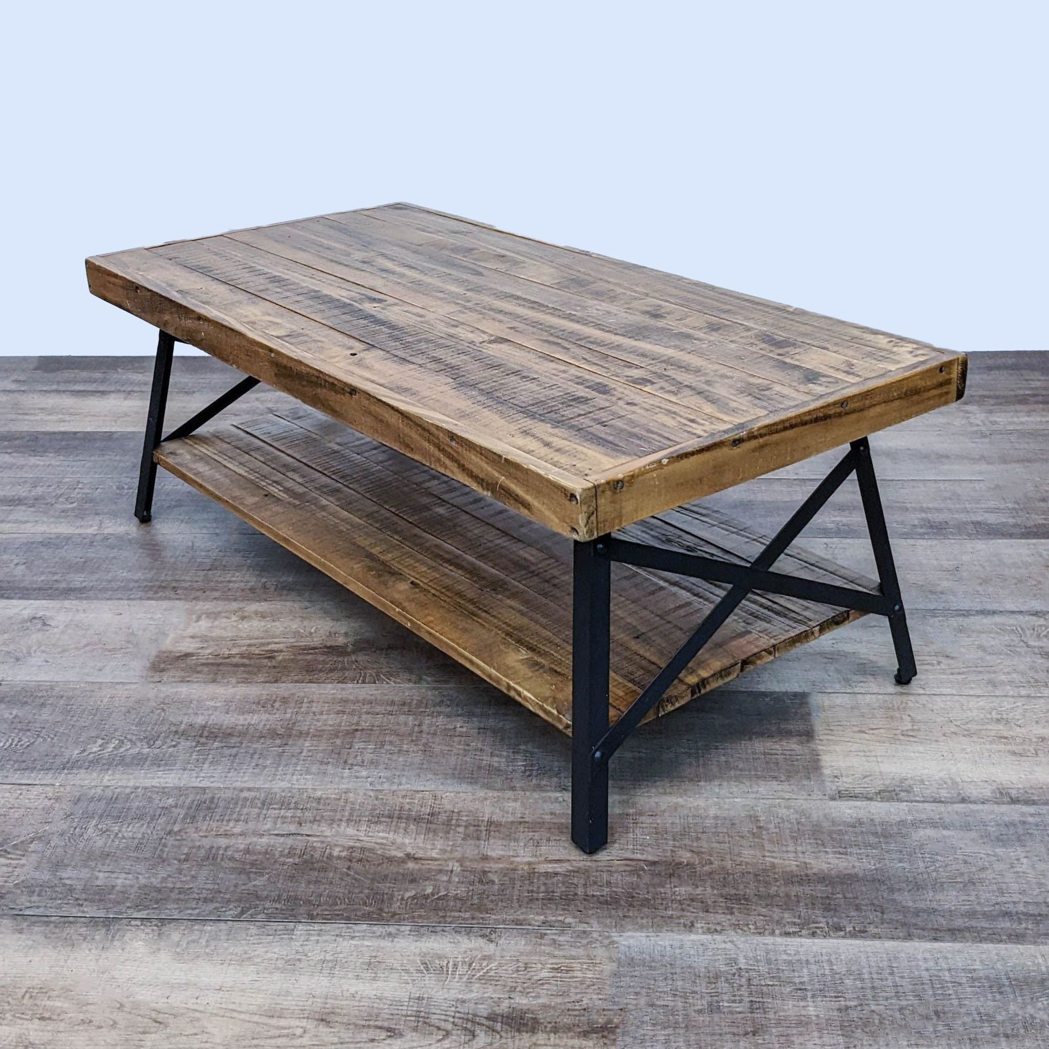 BoConcept coffee table with planked wood top and shelf, supported by black metal legs and bracings, on a wooden floor.