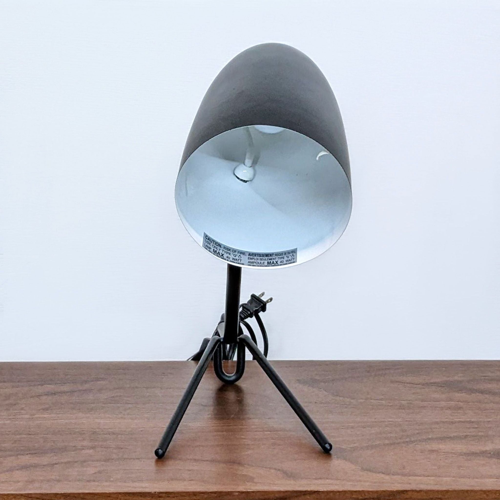 Modern Reperch desk lamp featuring a matte black finish, adjustable angle, and visible cord on a wooden desk.