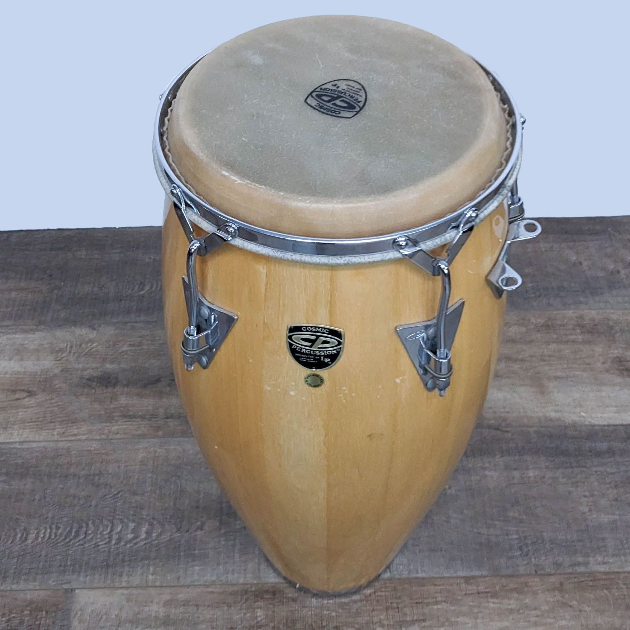 Alt text 2: Top view of a Cosmic Percussion conga drum showing the natural skin drumhead and chrome tuning lugs, ready for musical performance.